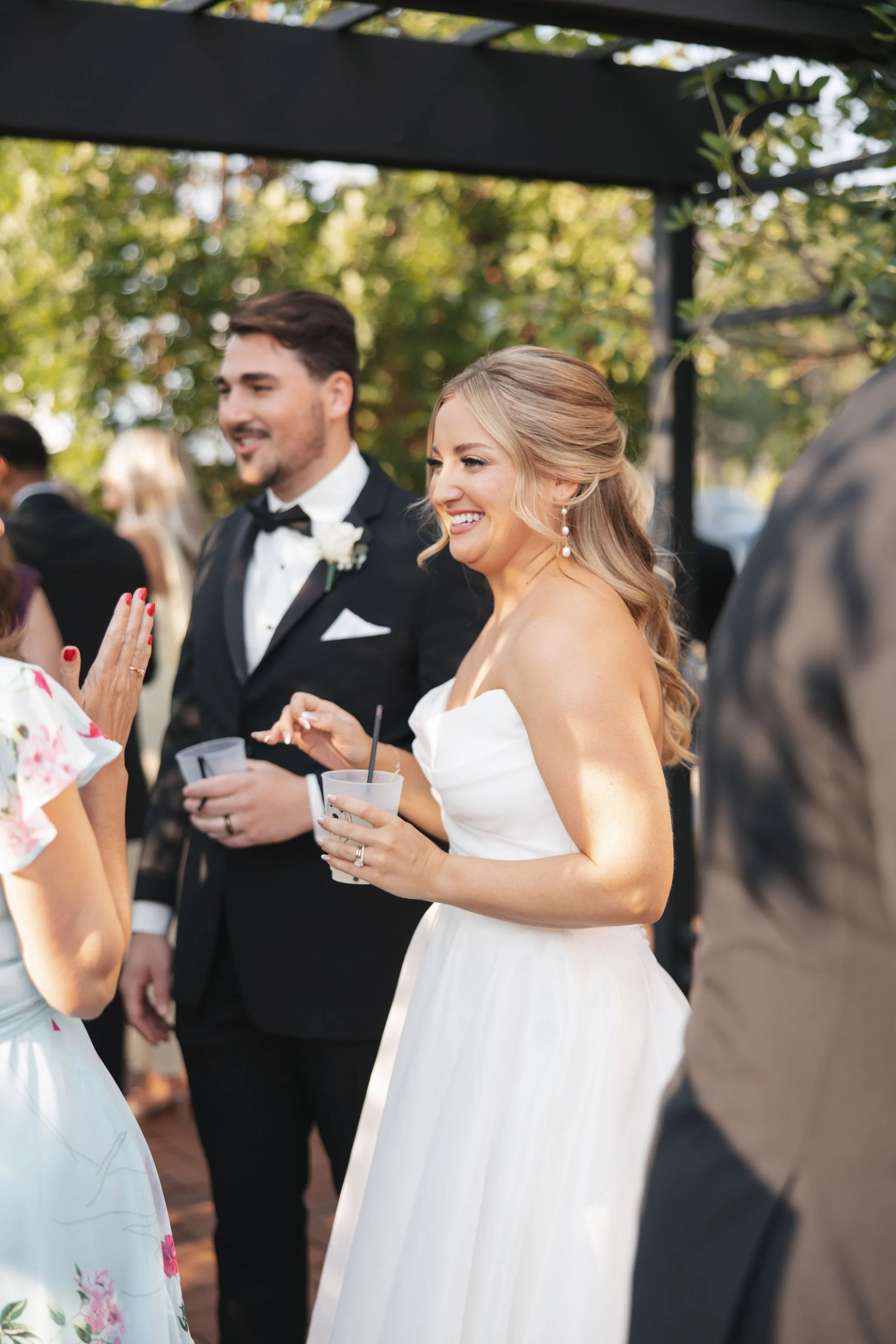 Bride and groom talking with wedding guests outside during cocktail hour