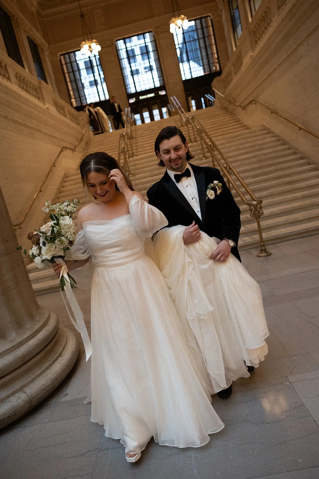 Couple candidly smiling and walking down stairs at Union Station in Chicago