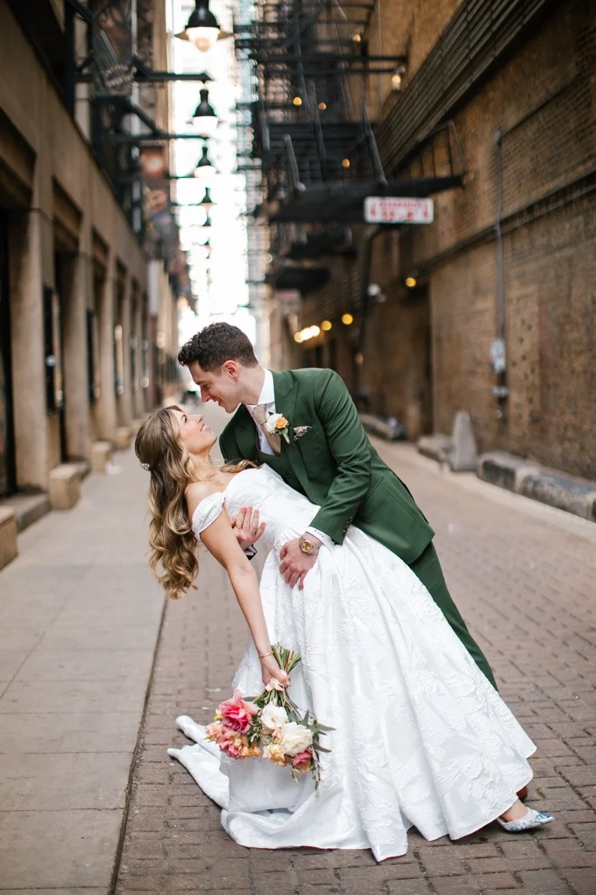 Groom dipping bride for wedding photos in alley of Theatre District in Chicago