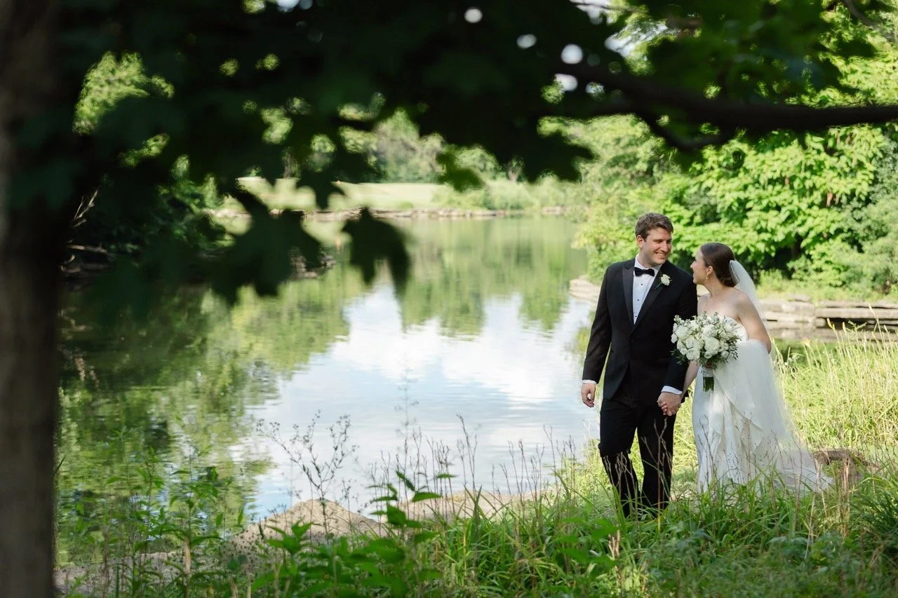 Bride and groom walking by a pond at Hyatt Lodge in Oak Brook