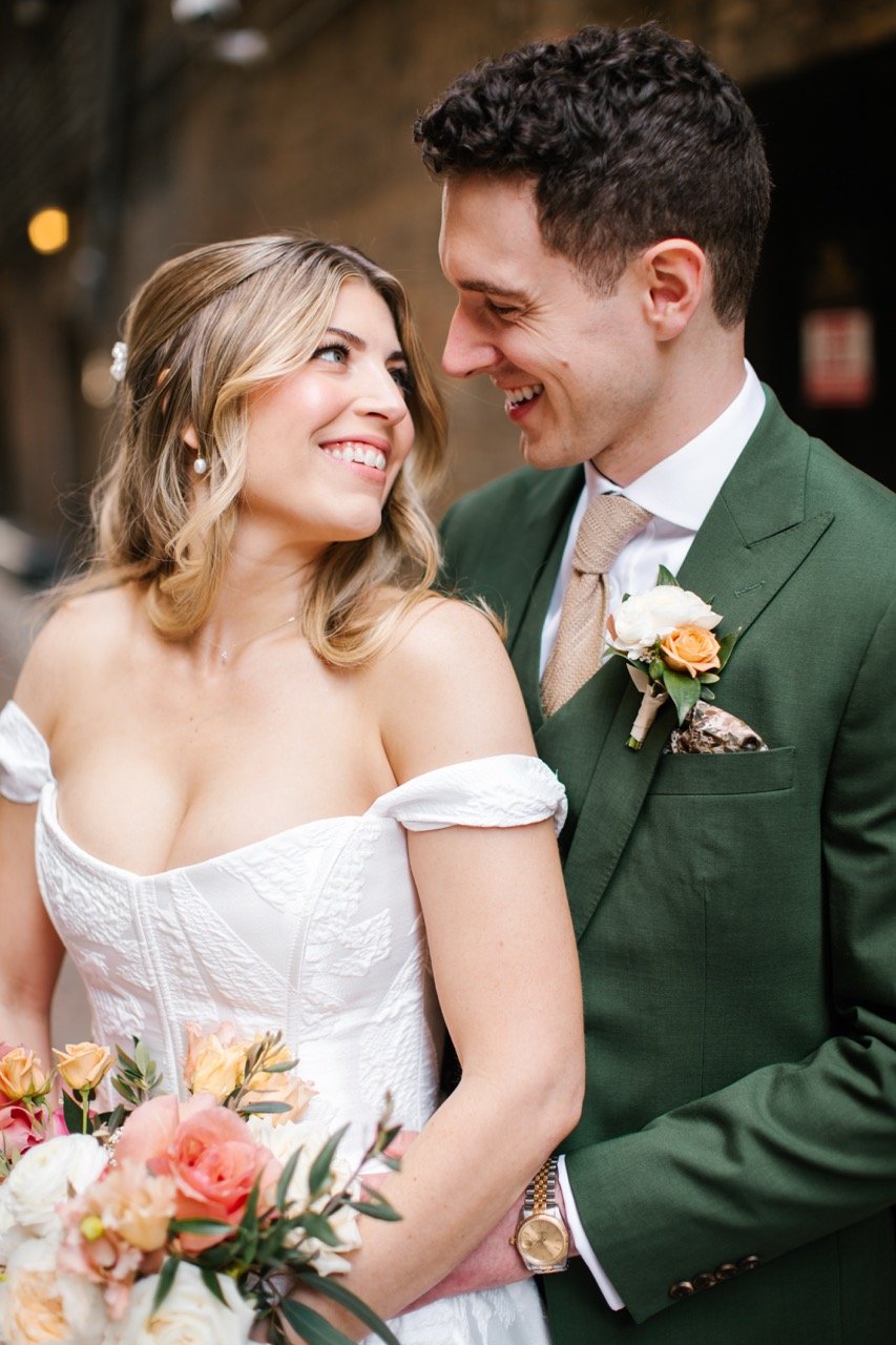 Bride and groom standing close to each other smiling