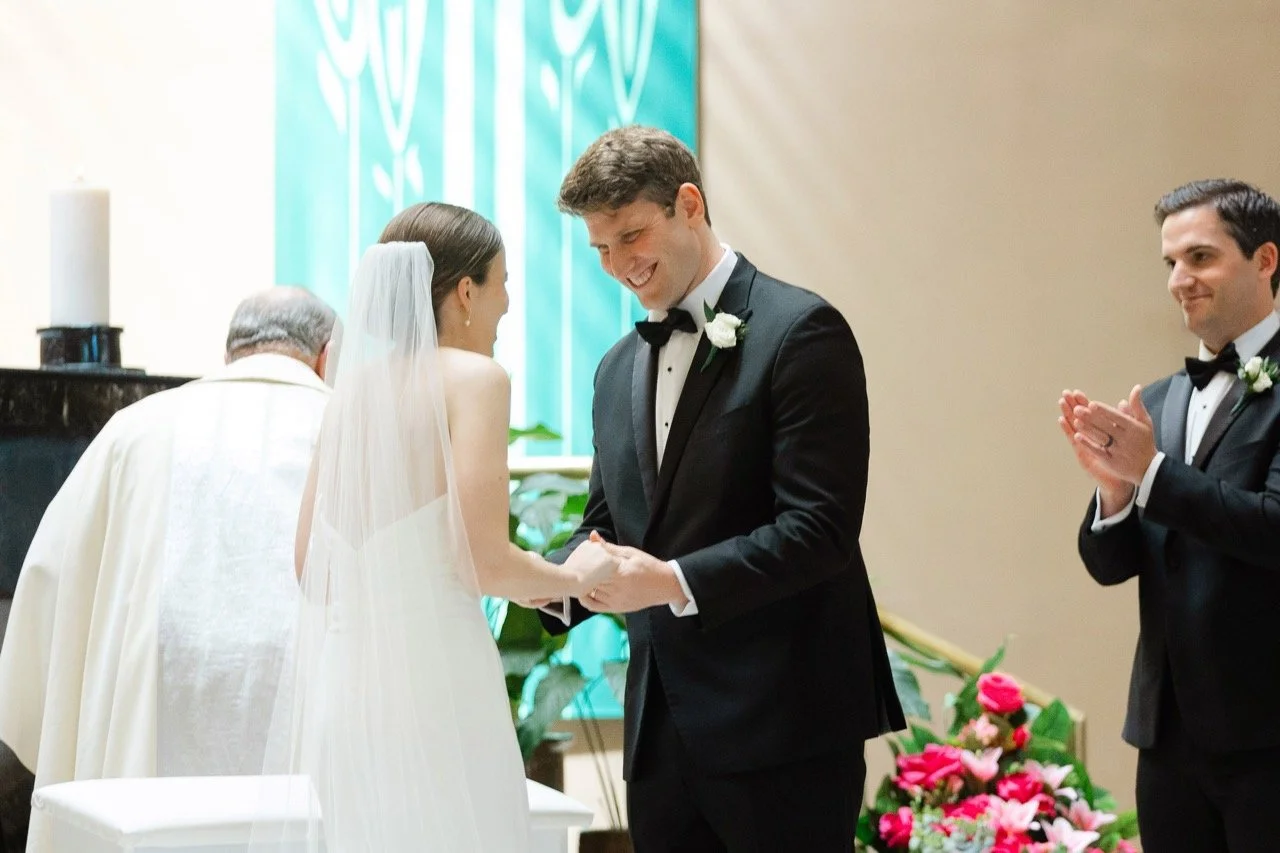 Bride and groom holding hands while giggling at wedding ceremony