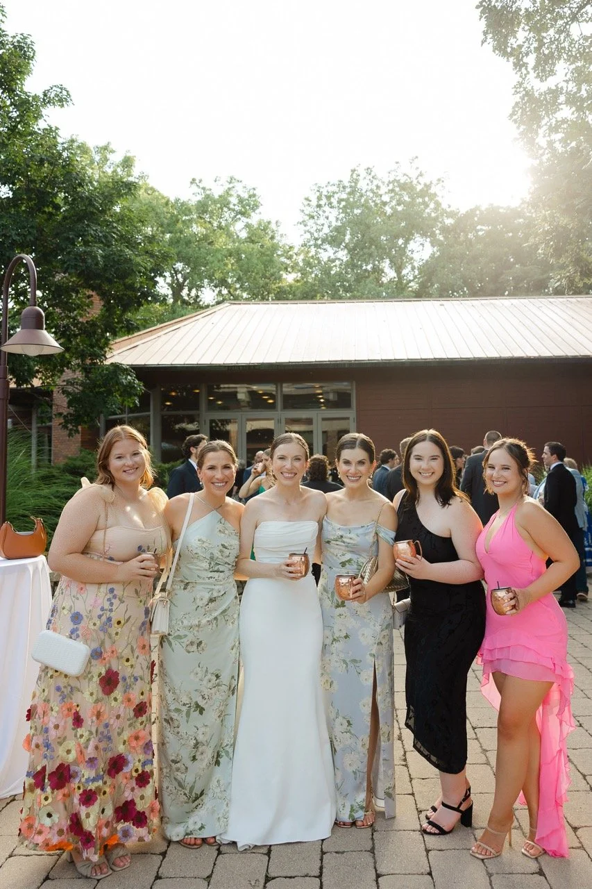 Bride smiling with wedding guests on outdoor patio of Grand Oaks Pavilion