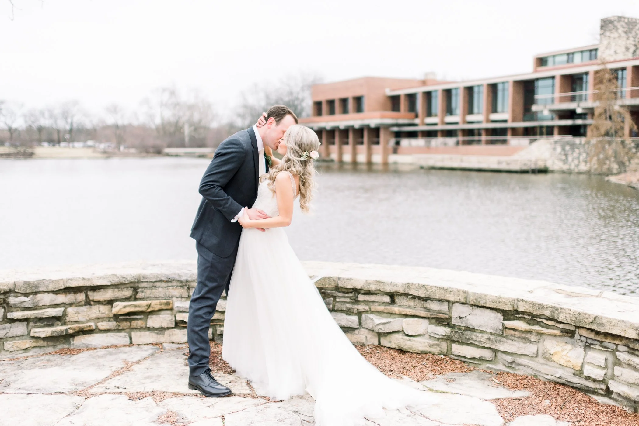 Couple on outdoor patio with Hyatt Lodge in Oak Brook as the background near pond