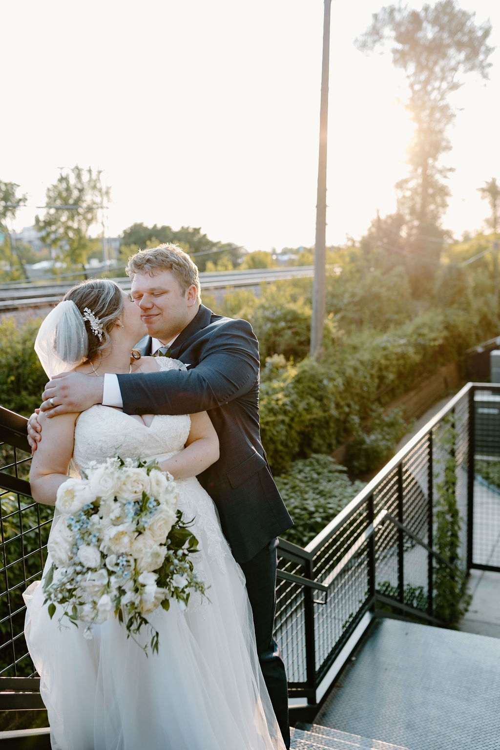 Couple standing on staircase on outdoor patio about to kiss