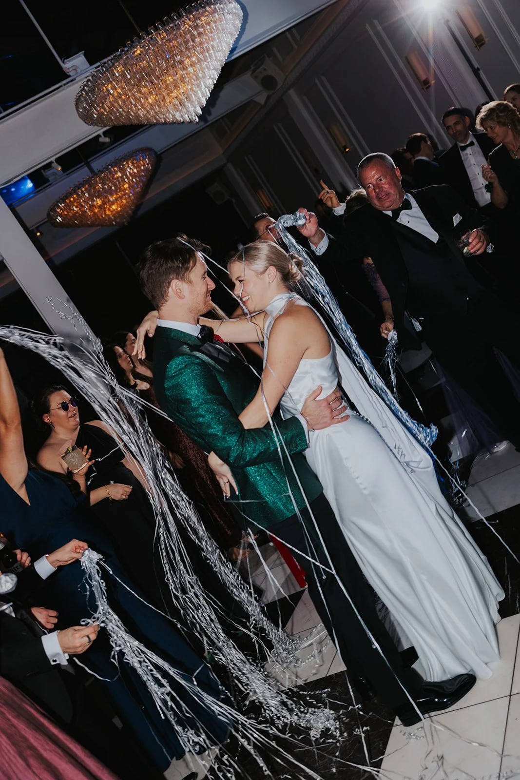 bride and groom smiling at each other with streamers thrown by wedding guests at reception in Chicago