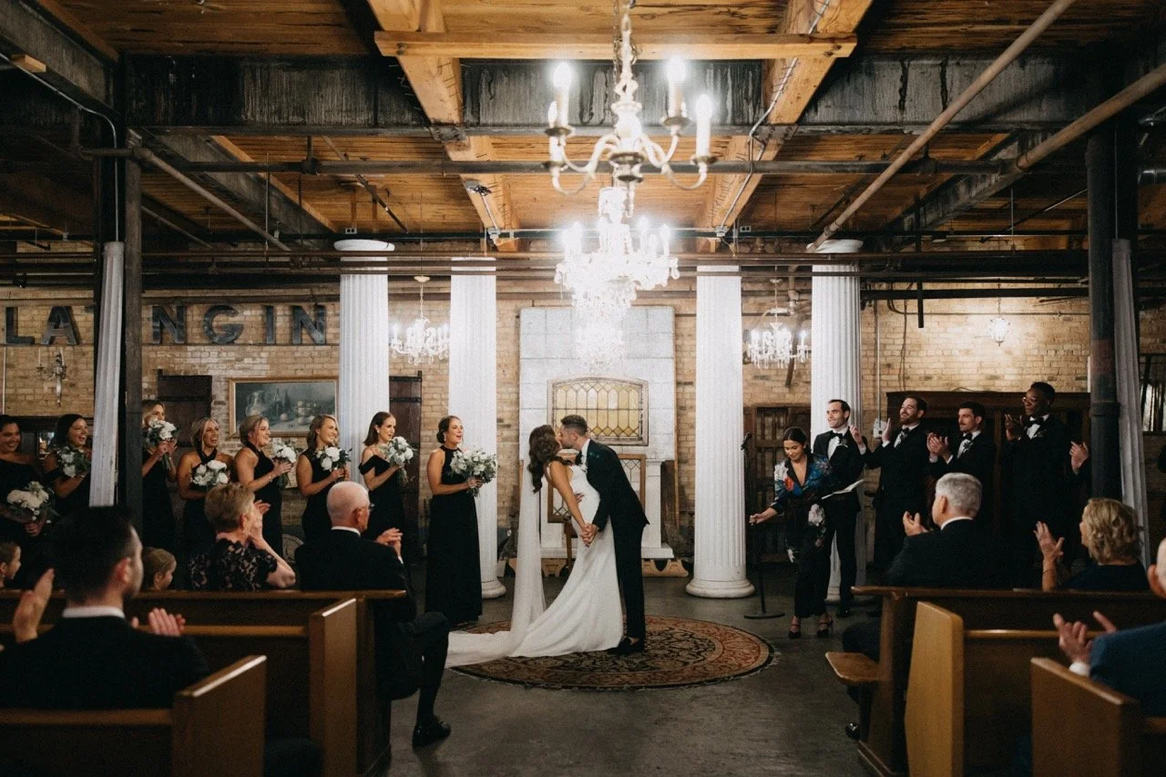 First kiss with wedding party cheering at wedding ceremony at Salvage One