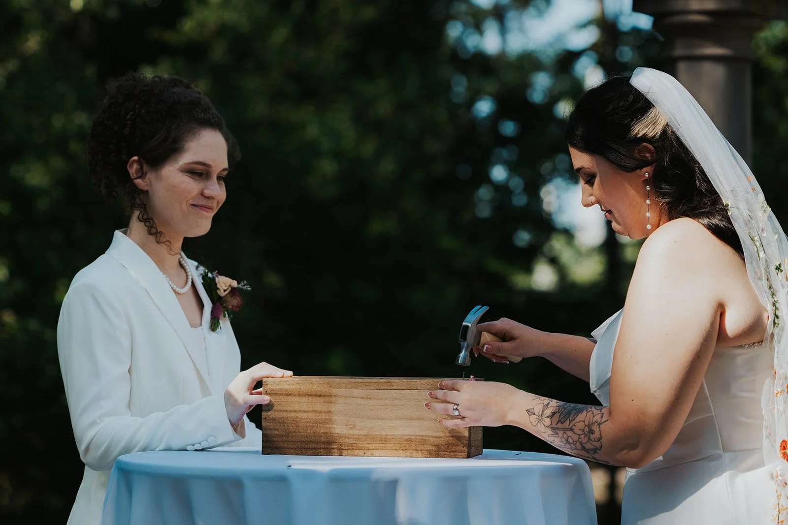 Gazebo wedding unity wine box ceremony with bride in dress hammering box while bride in suit supports it