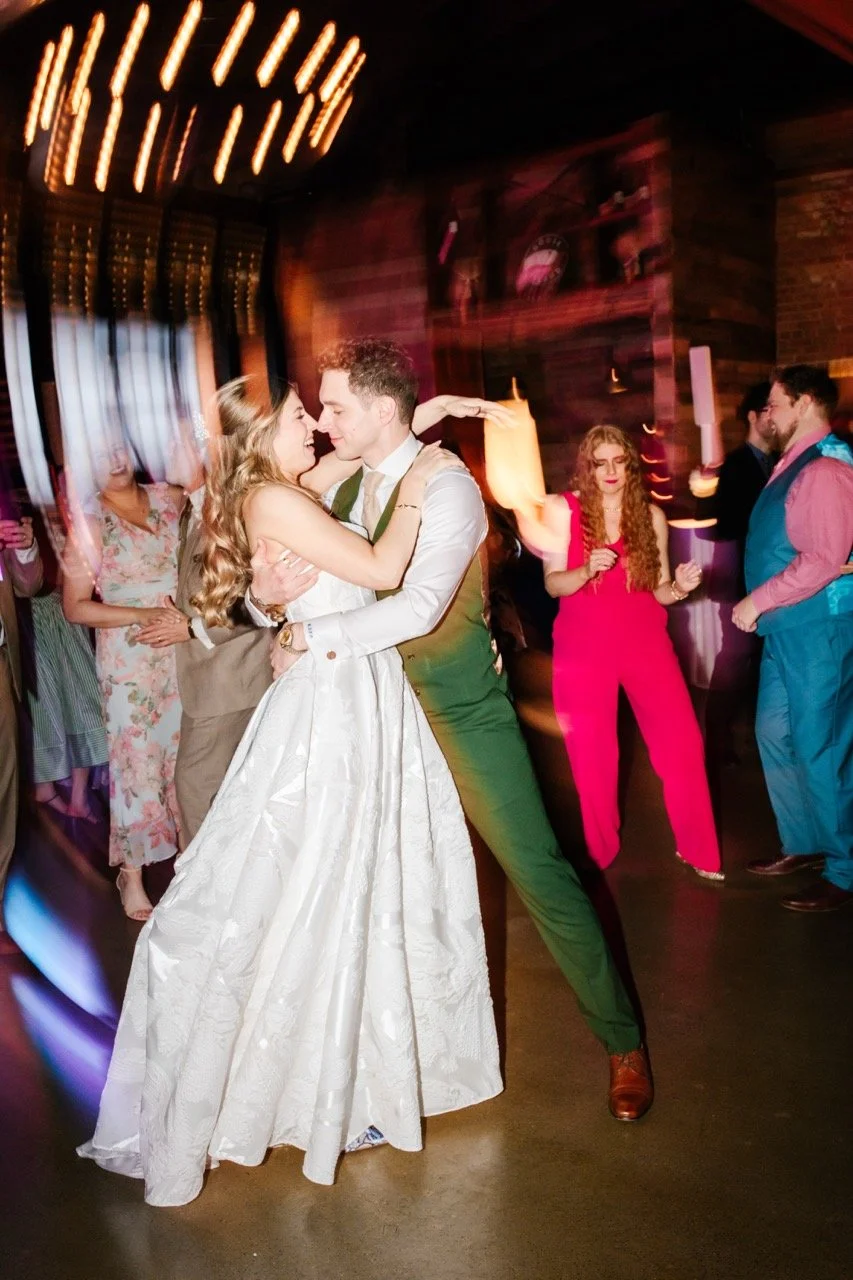 Couple on dance floor surrounded by wedding guests at wedding reception