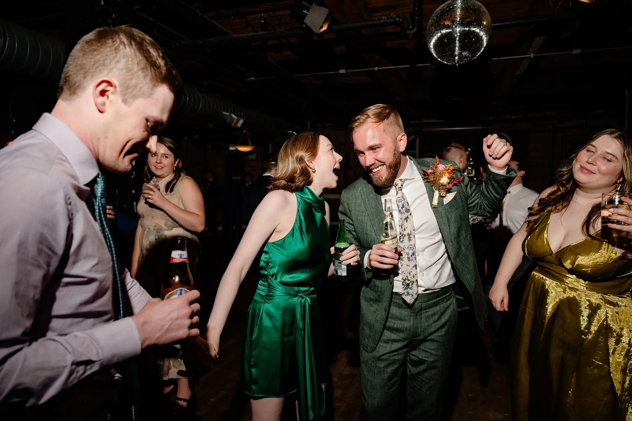 One groom smiling and dancing with many guests on the dance floor