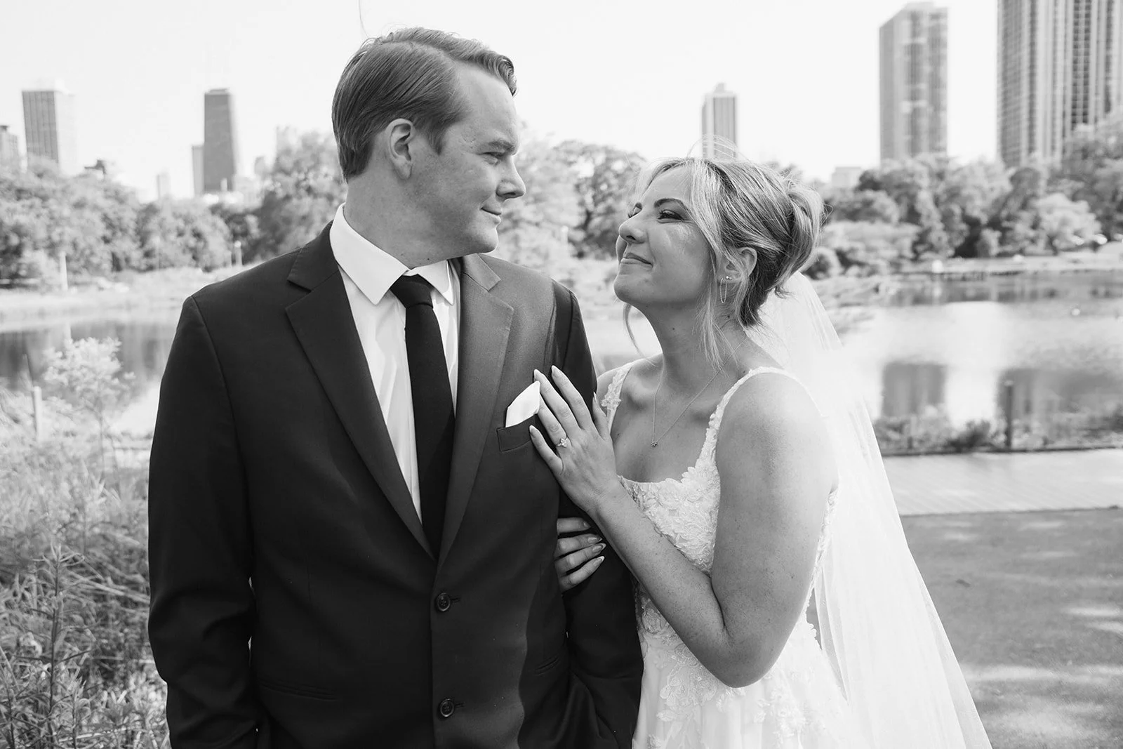 Black and white photo of couple looking at each other grinning outdoors in Lincoln Park Zoo