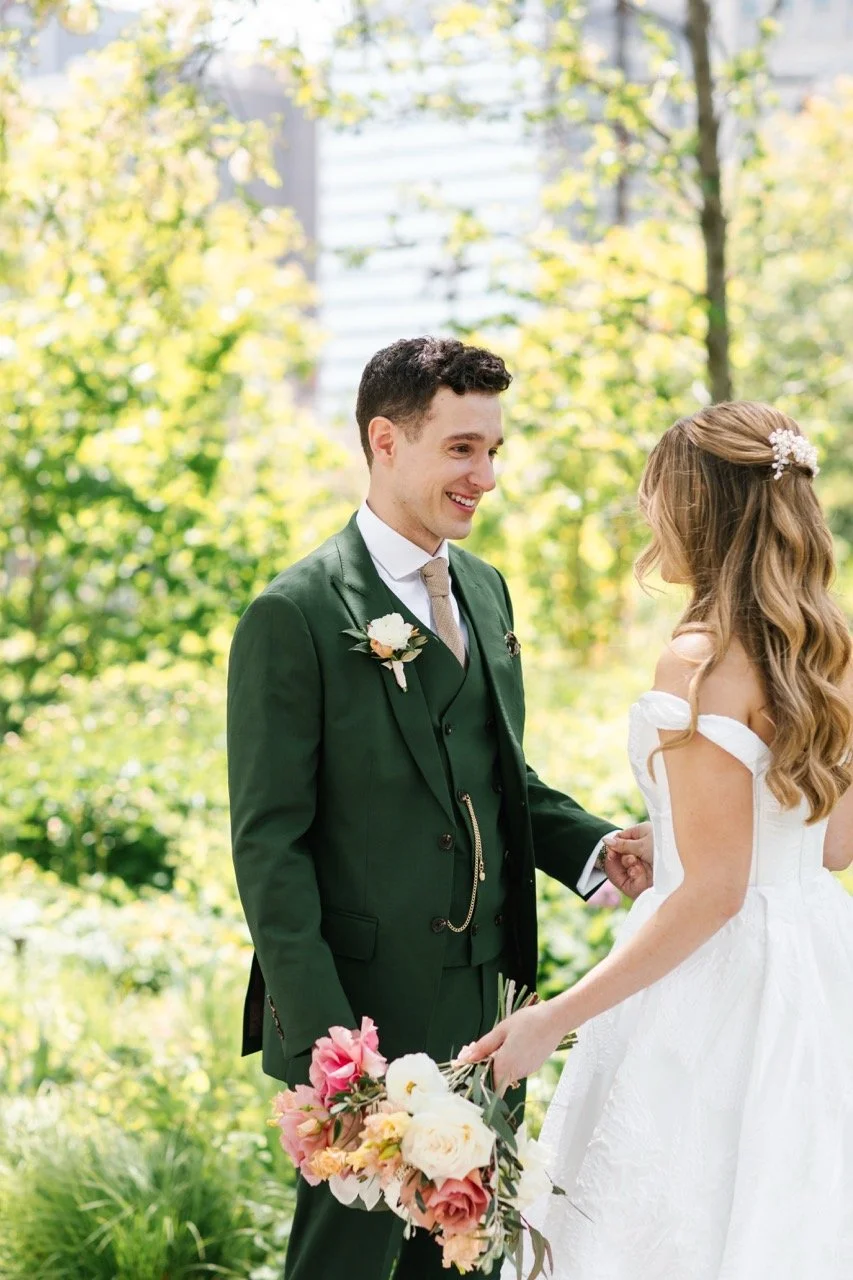 Groom holding bride's hand while tearing up at first look before wedding ceremony at Goose Island Barrel House