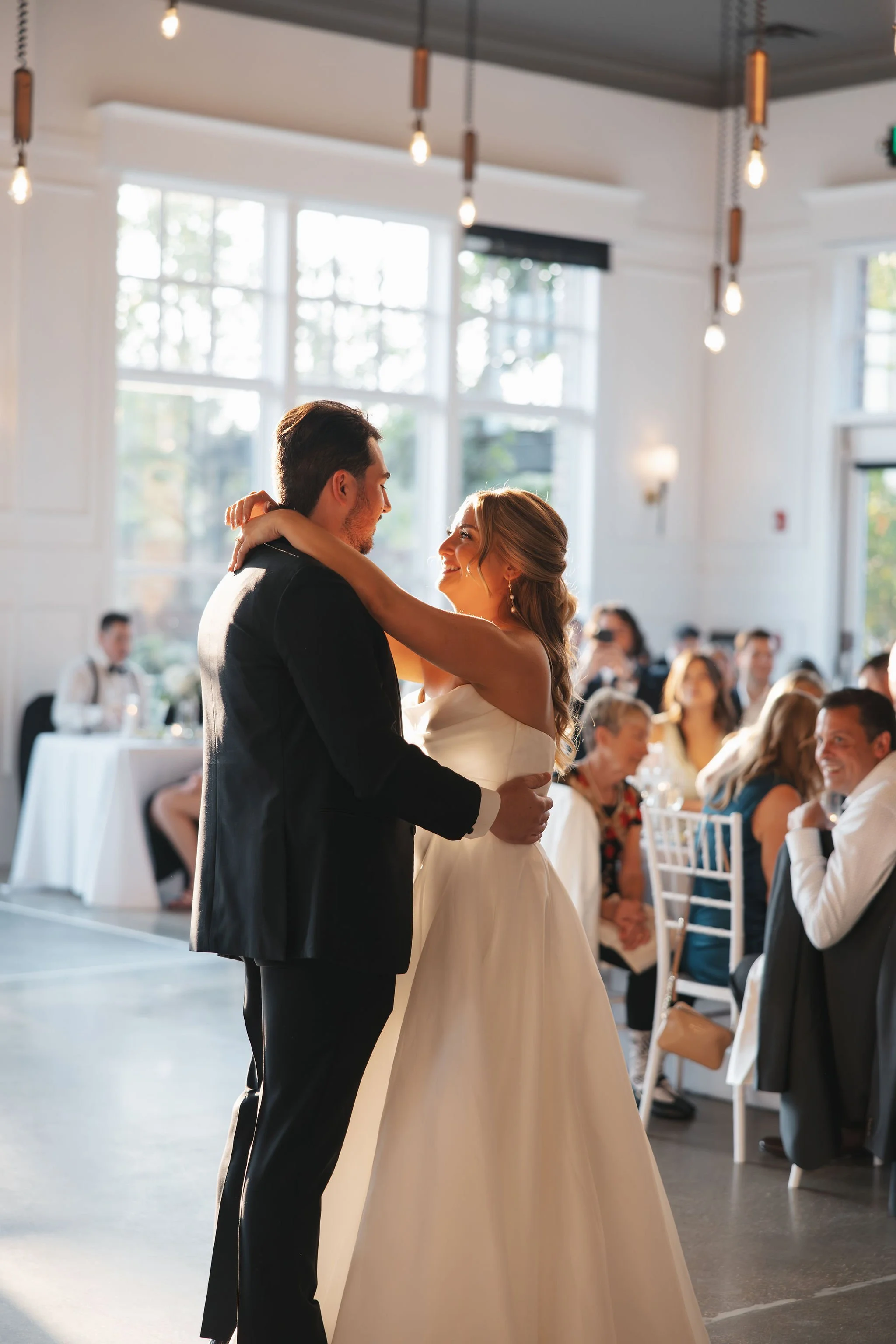 Bride and groom first dance on dance floor close up of them smiling at each other