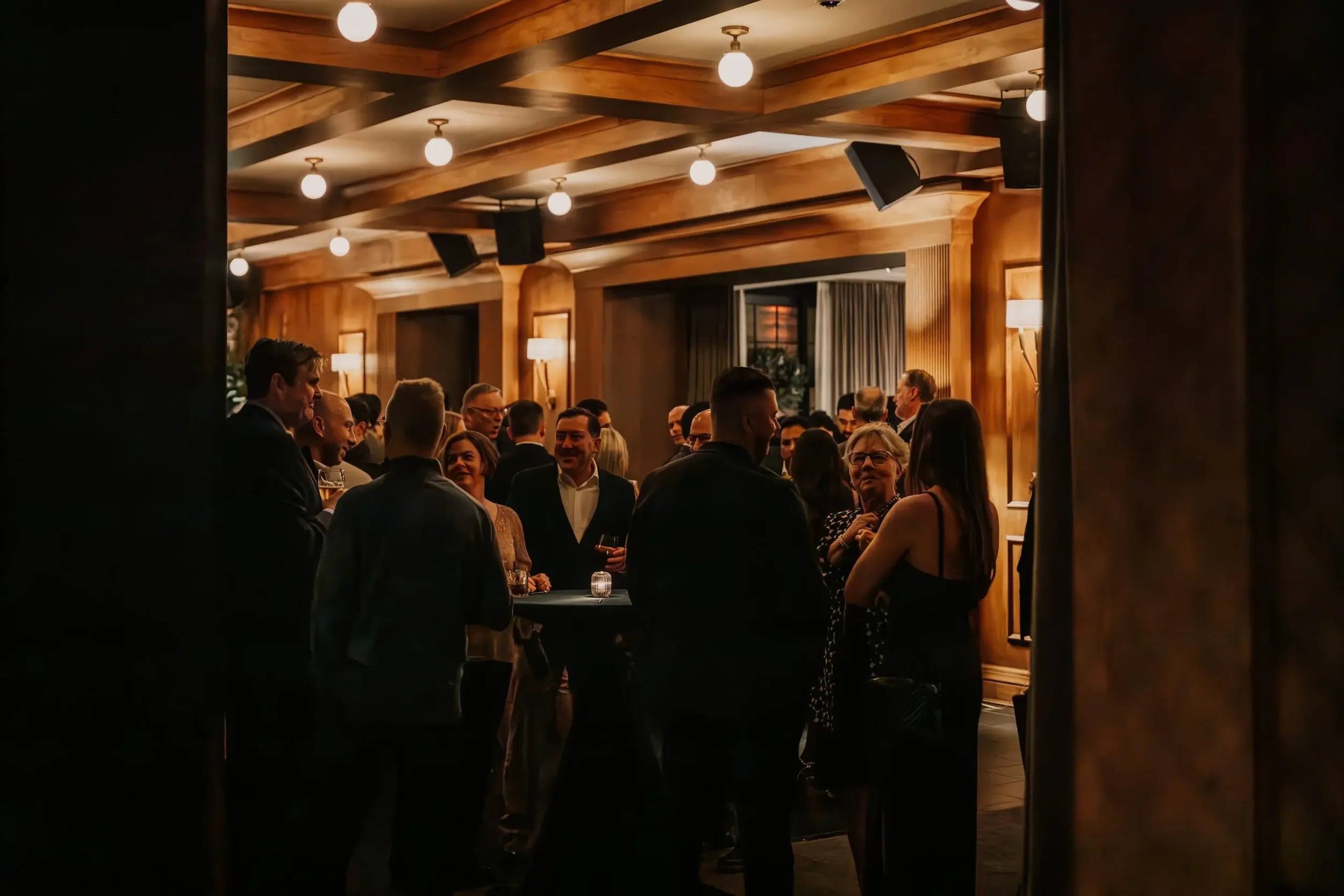 Jazzy cocktail hour space with people mingling and mood lighting at Salon 61 Events