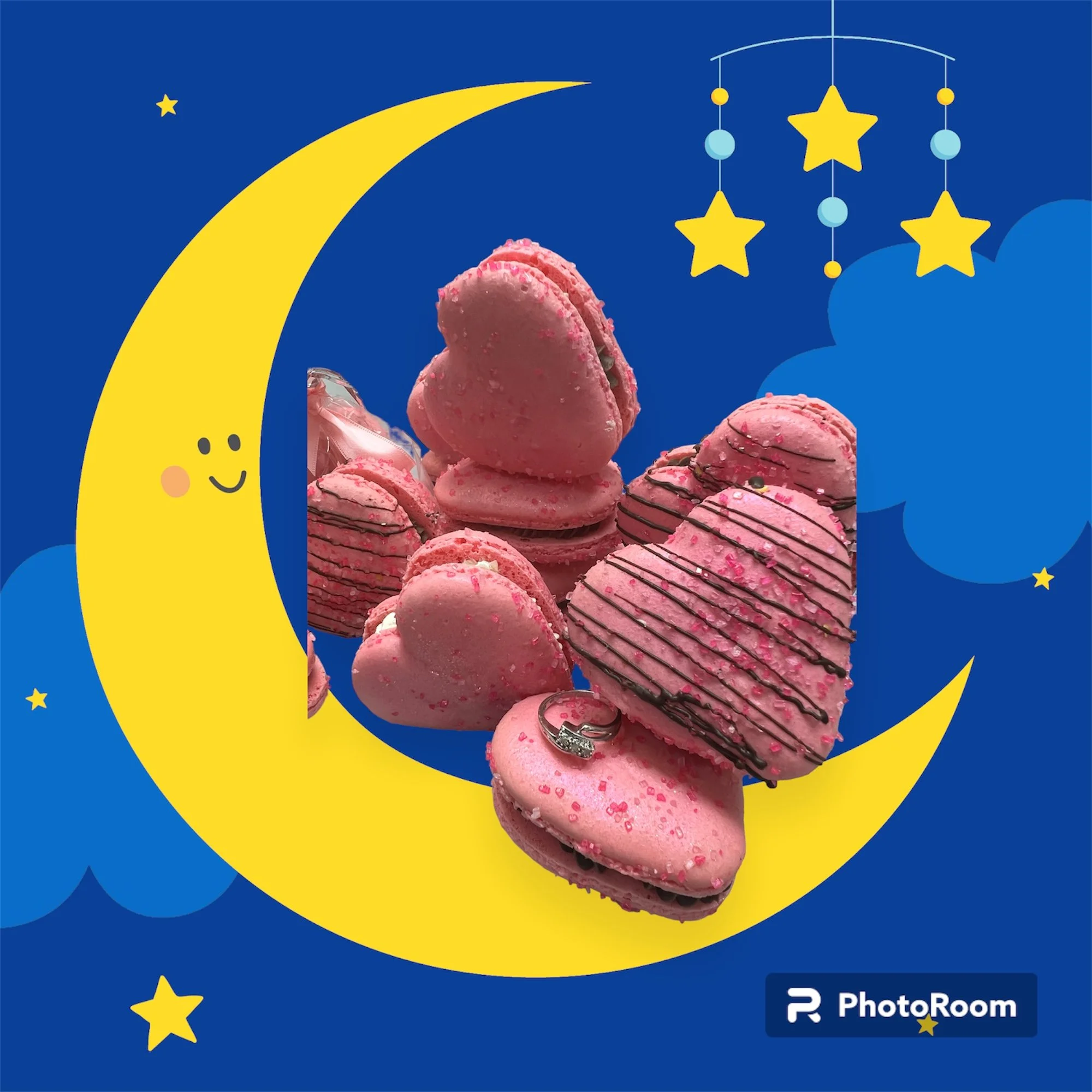 Pink heart-shaped macarons with chocolate drizzle and sprinkles, set against a whimsical night sky illustration featuring a smiling crescent moon, stars, and clouds.
