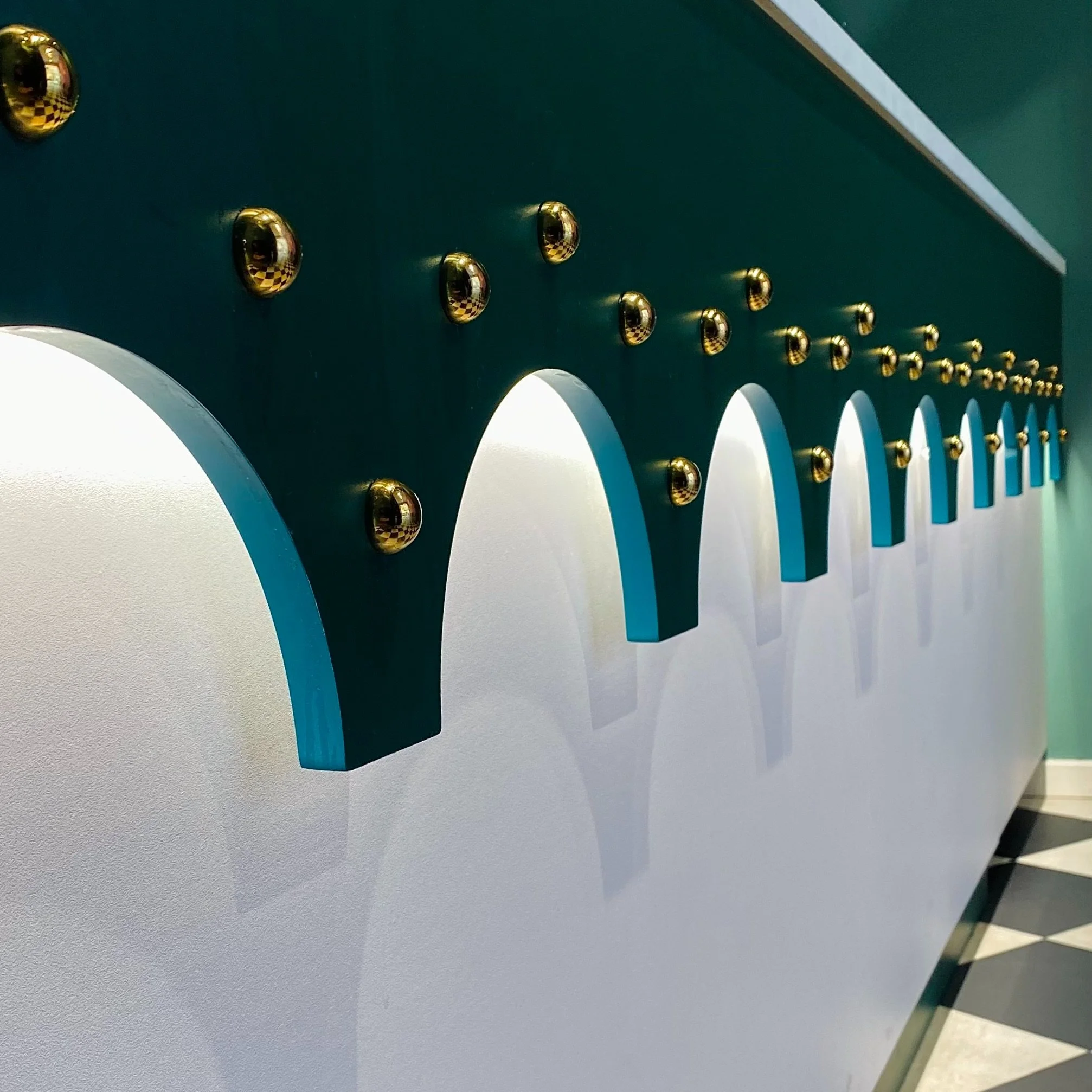Arched brass ring wall detail, bubble tea room interior, Copenhagen