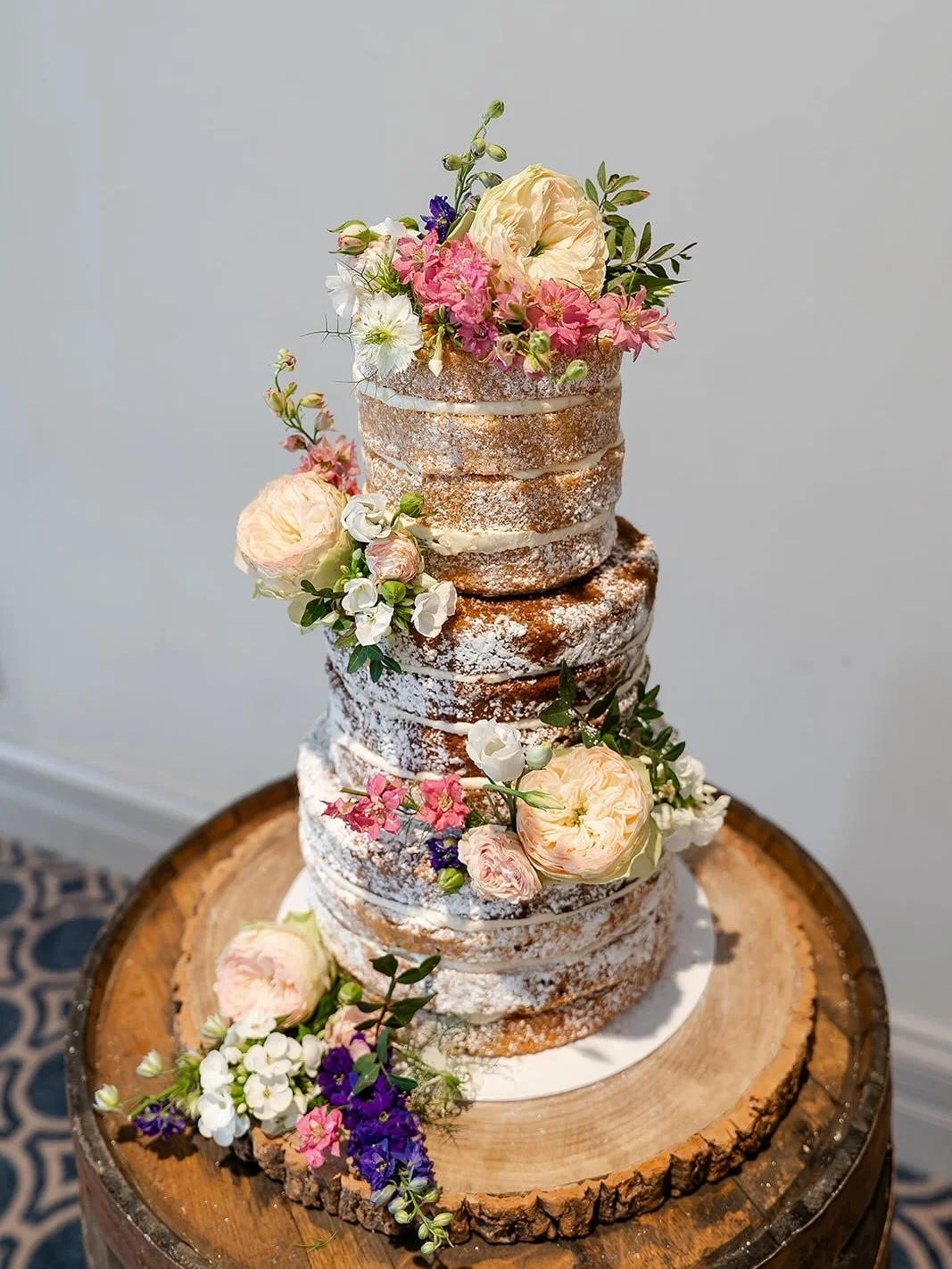 J&amp;C @bowoodweddings 🥂🍰

A naked finish with a dusting of icing sugar and fresh flowers from  Derry Hill Florist 🌻🌸💕

Photos from @copperandblossom