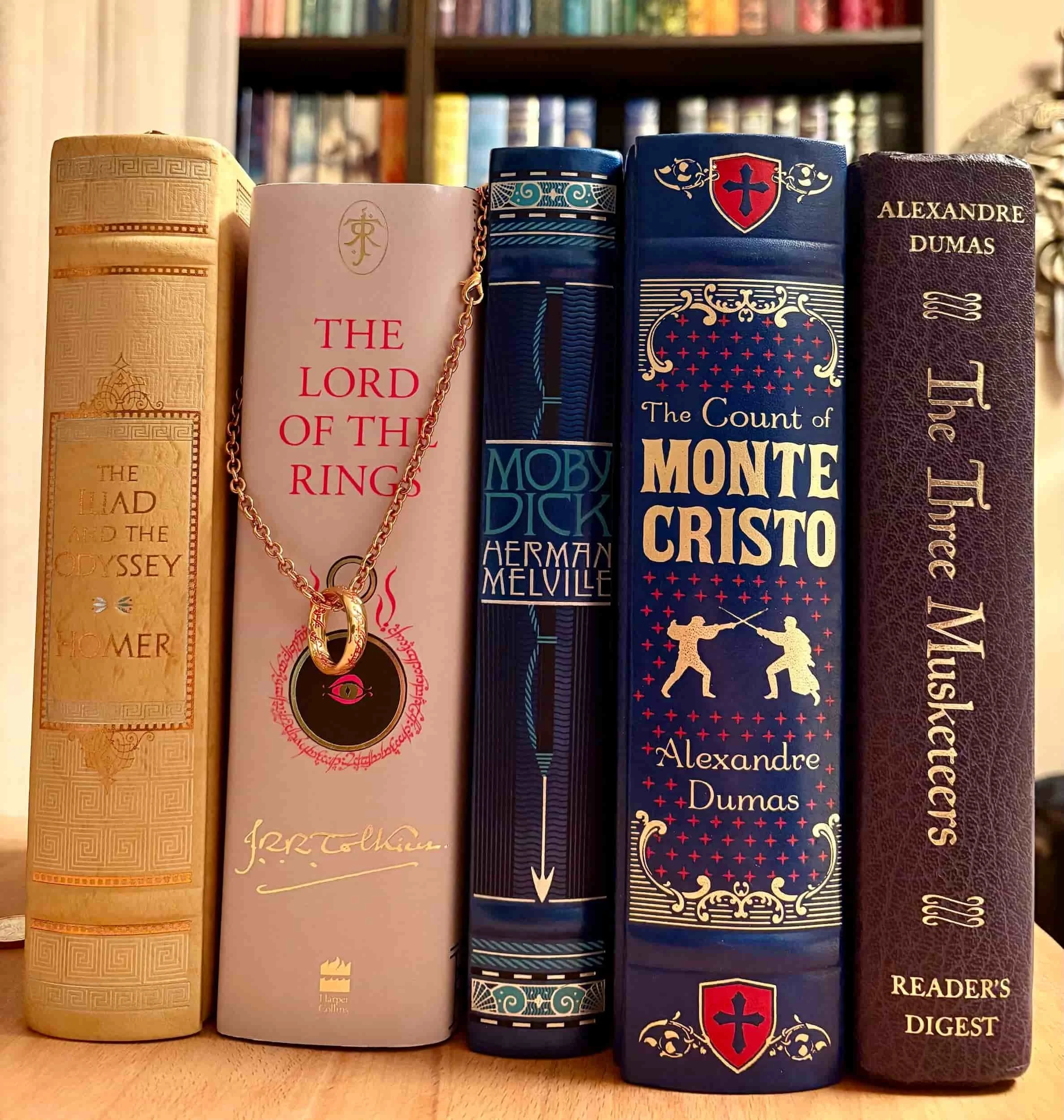 Physical copies of classic epic adventure books including The Count of Monte Cristo, The Lord of the Rings, and Moby-Dick.