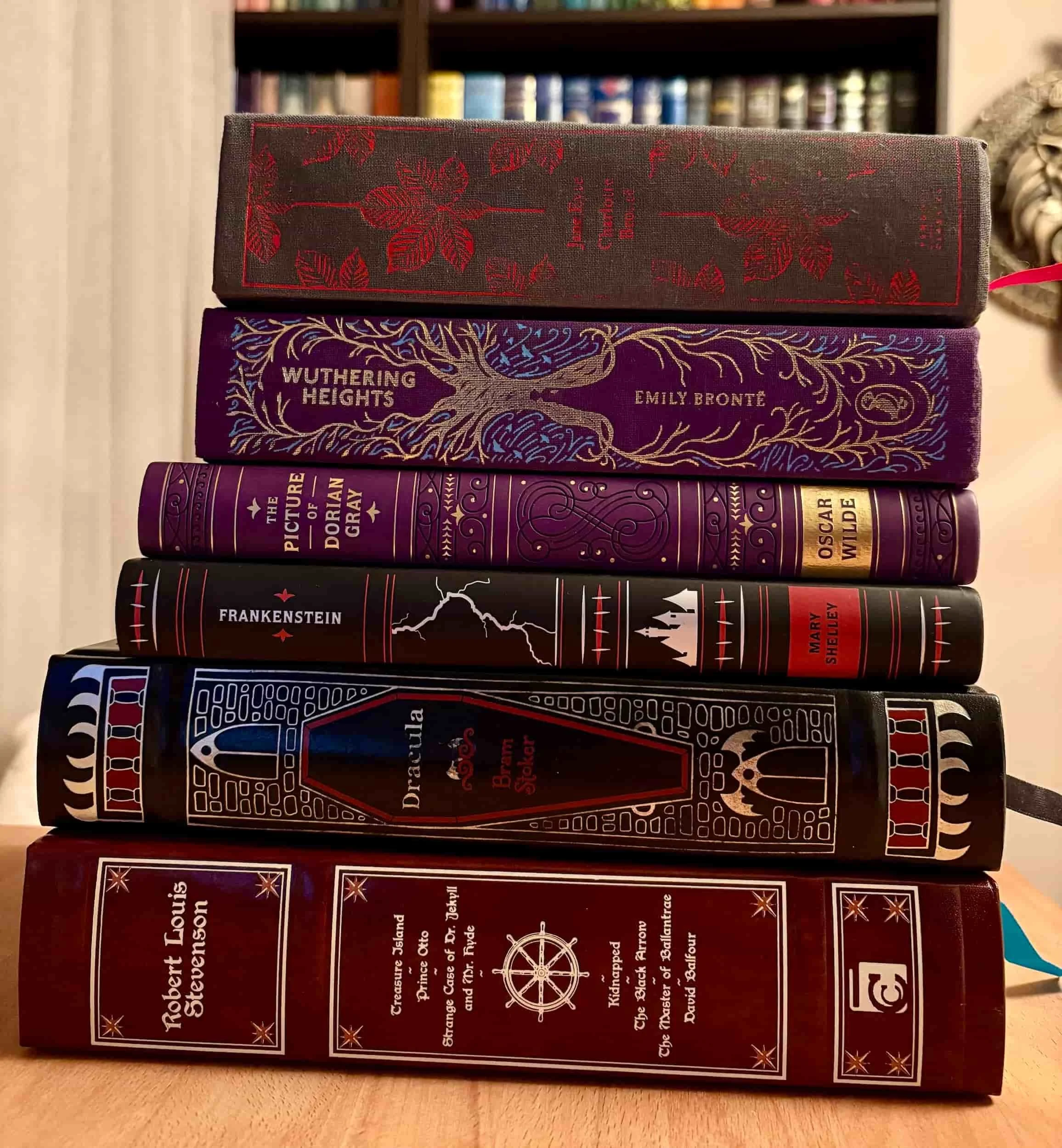 A stack of dark gothic classic literature books featuring Frankenstein, Jane Eyre, and Wuthering Heights.