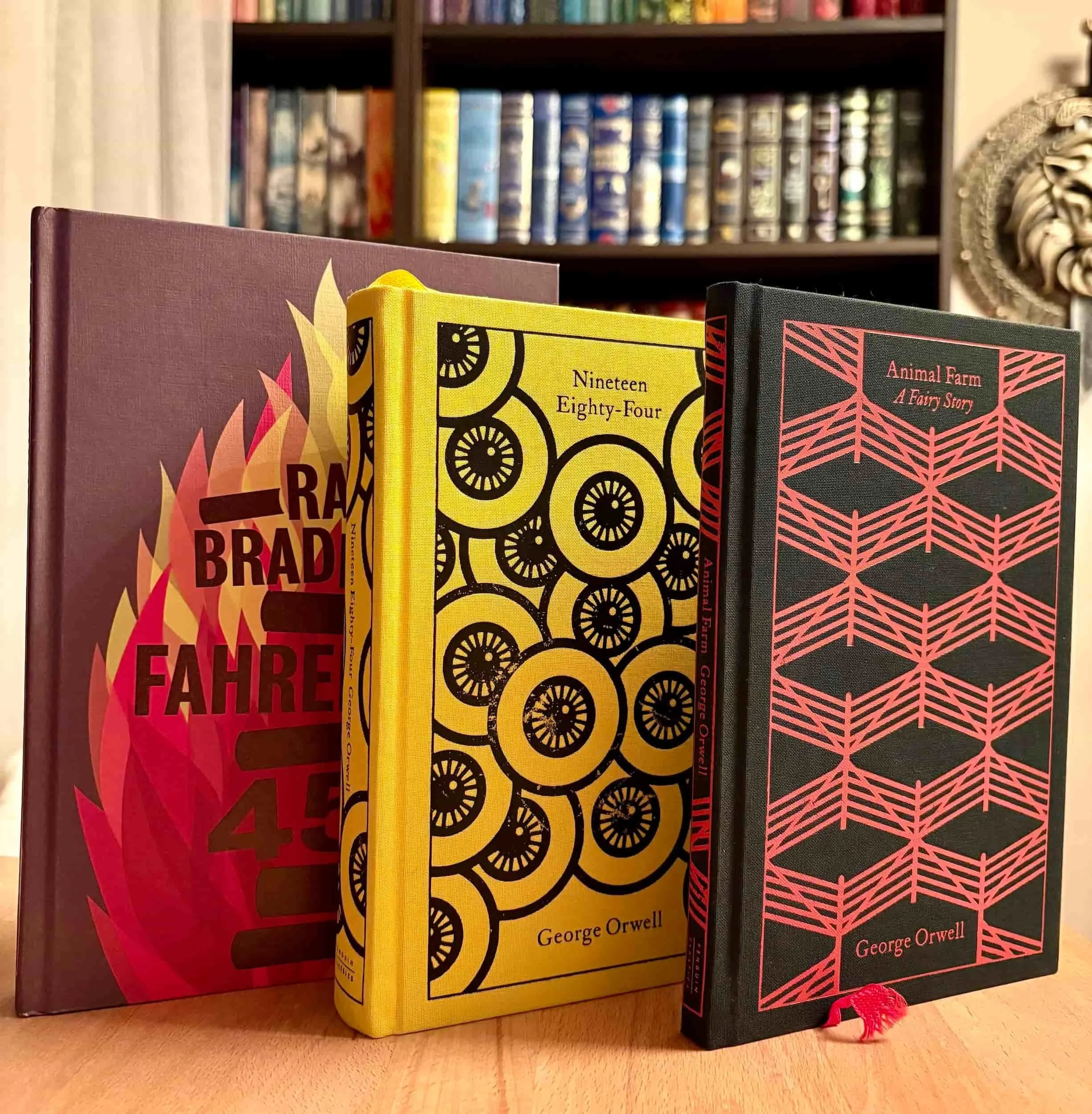 Classic dystopian novels including George Orwell's 1984 and Animal Farm stacked on a bookshelf.