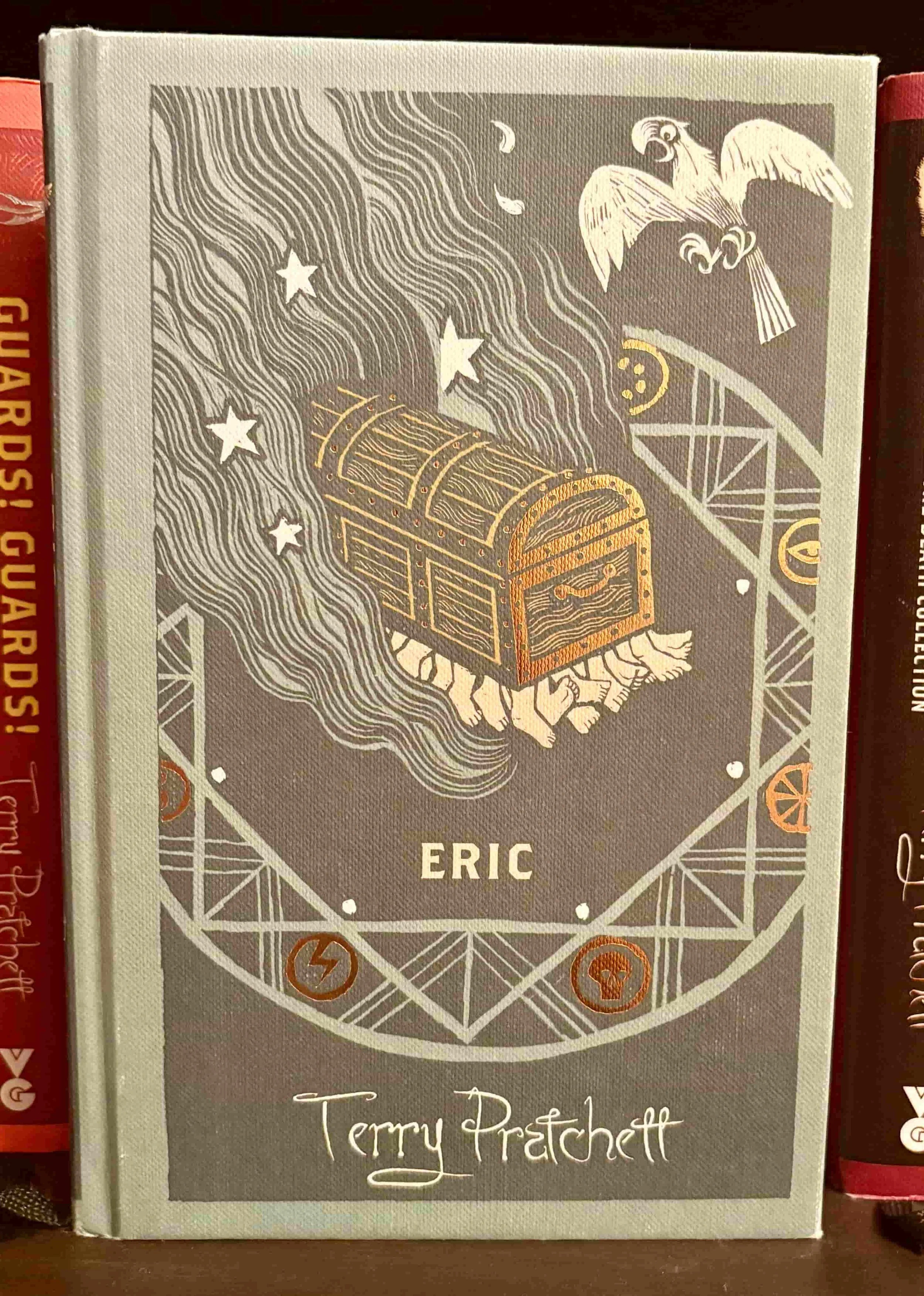 The blue cover of Eric by Terry Pratchett, featuring magical symbols.
