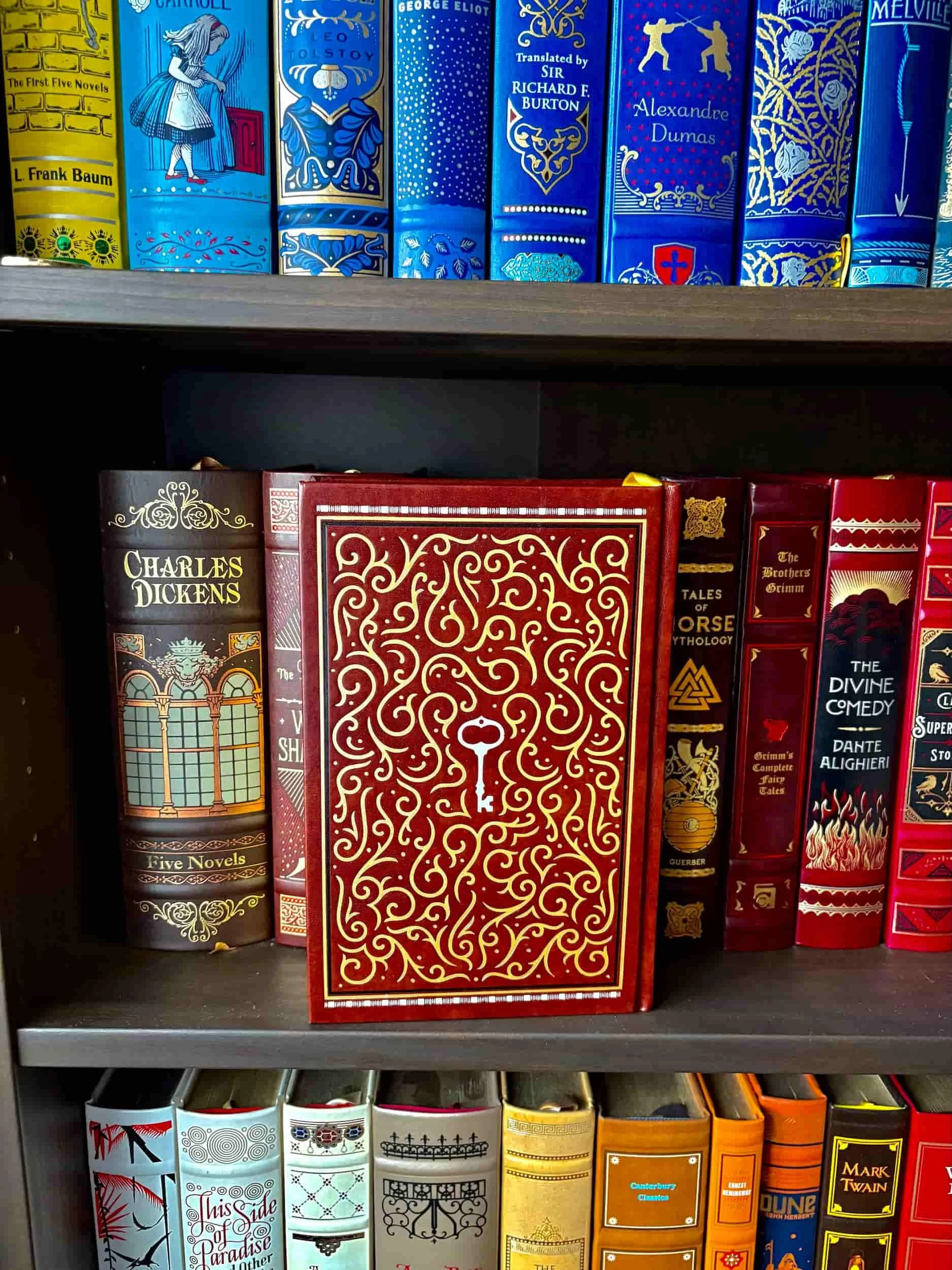 The Complete Sherlock Barnes and Noble Omnibus edition standing upright on a shelf showcasing the back cover, which features a swirly design with a silver key in the middle