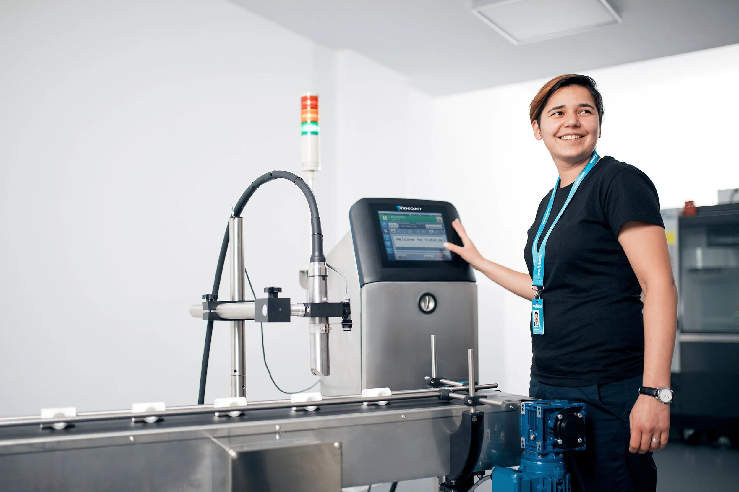 Multitech industrial equipment in a production facility, with a technician standing beside the machinery.