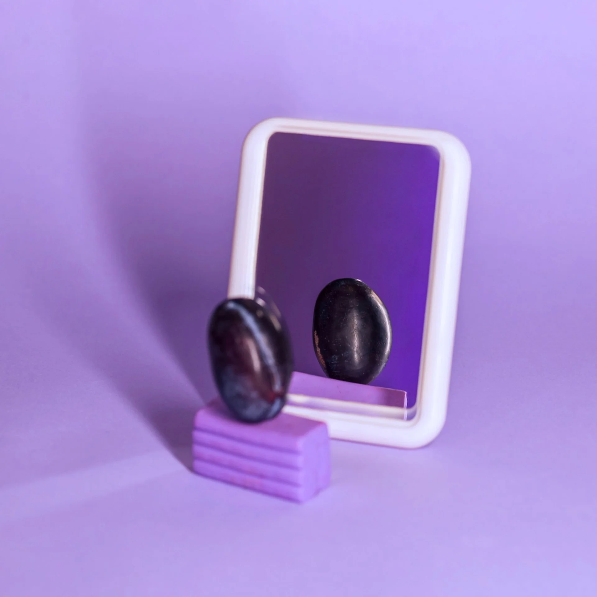 Sculptural objects arranged in front of a mirror in a purple studio setting, illustrating Plumline's brand strategy process.