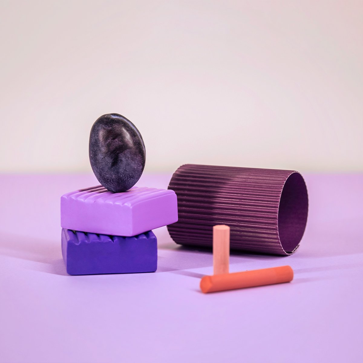 Sculptural objects in purple, plum and coral arranged as a still life, illustrating the visual details that bring a brand identity to life.