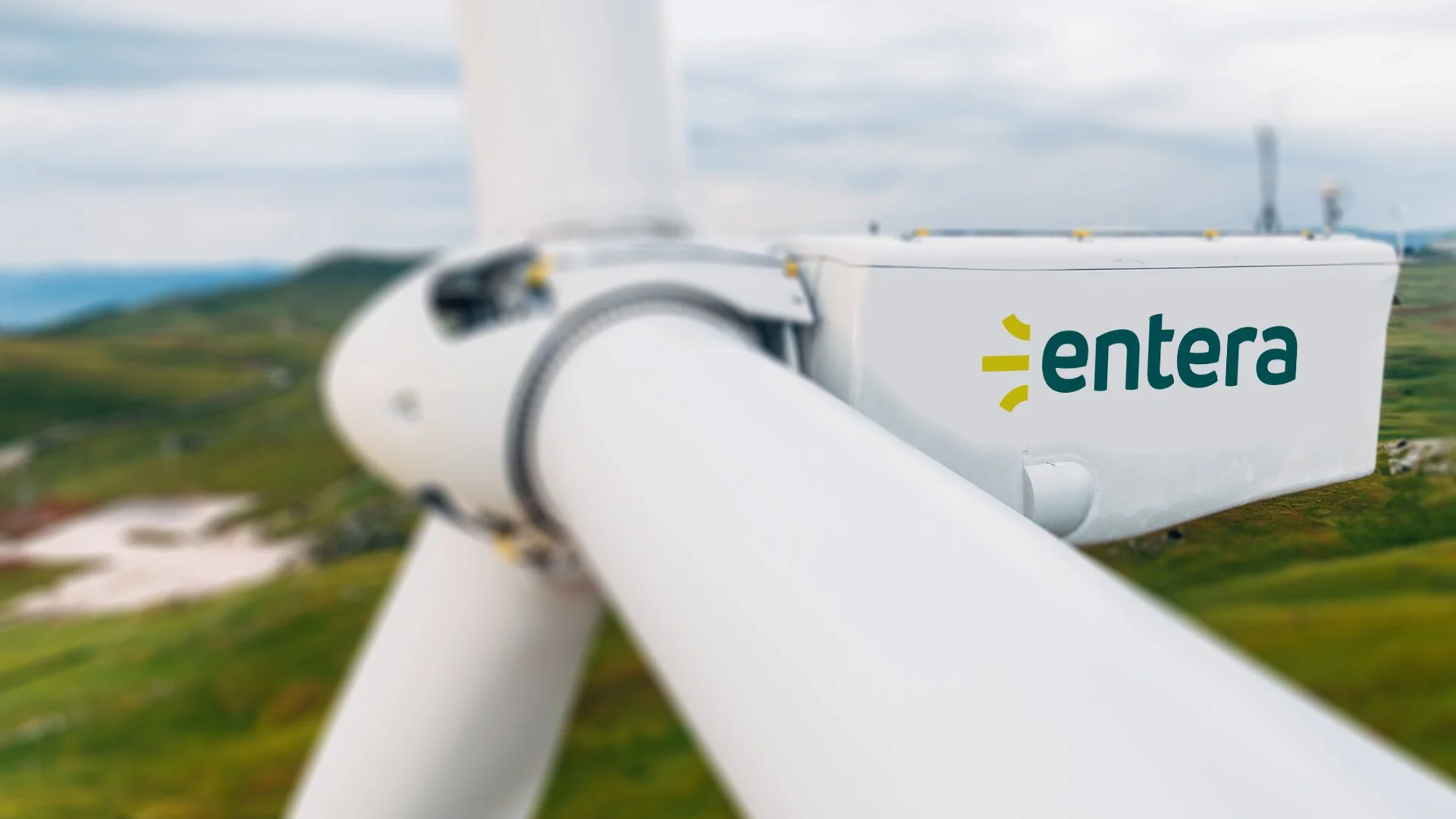Entera renewable energy brand identity displayed on a wind turbine in a green landscape.