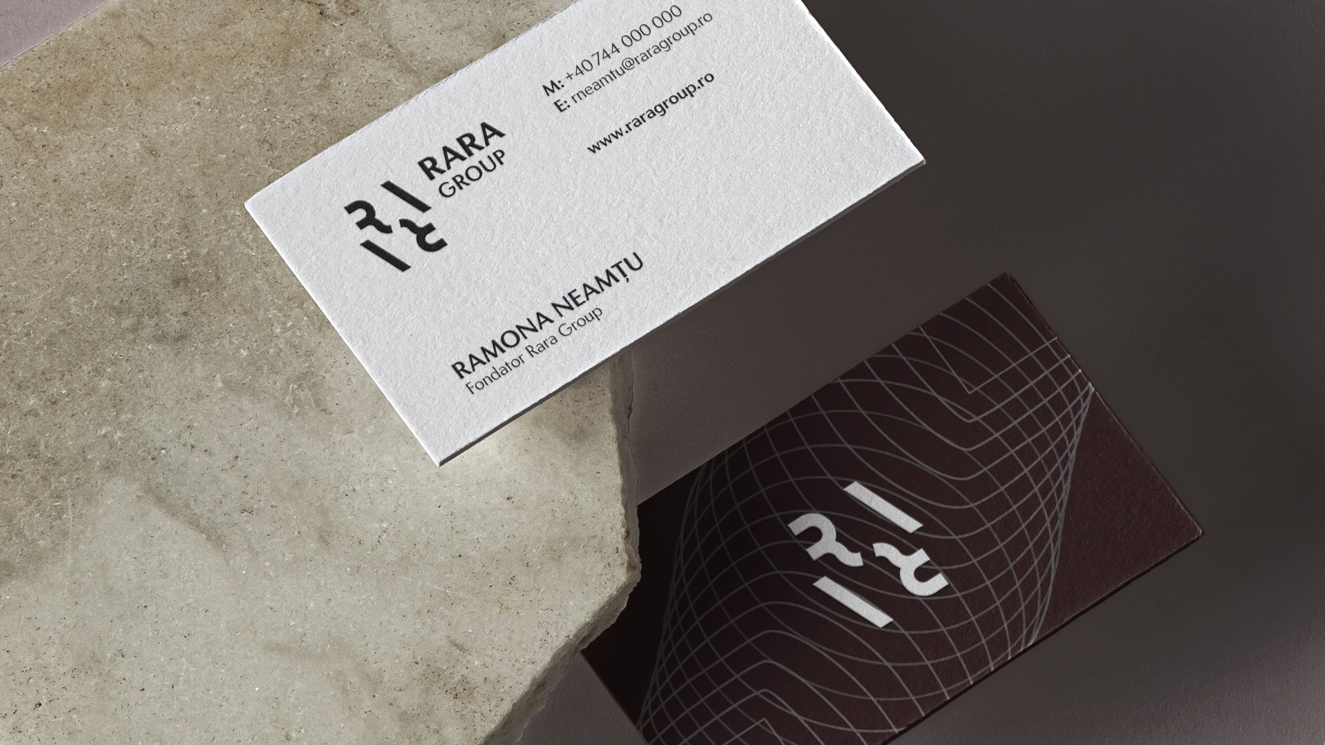 Rara Group business cards featuring the geometric monogram, corporate details and fine-line graphics on cream and dark burgundy background.