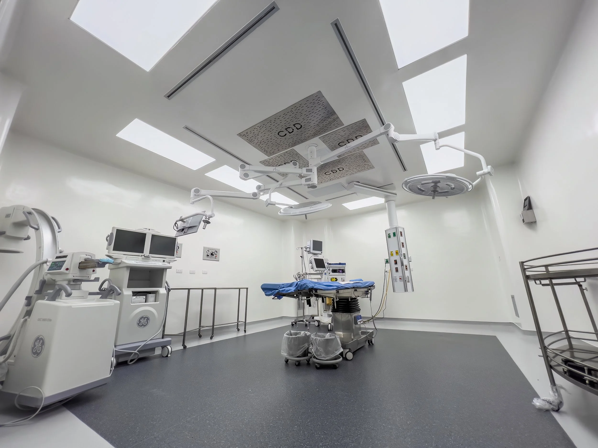 Sala de operaciones en un hospital, equipada con monitores, iluminación brillante y equipo médico para cirugía.