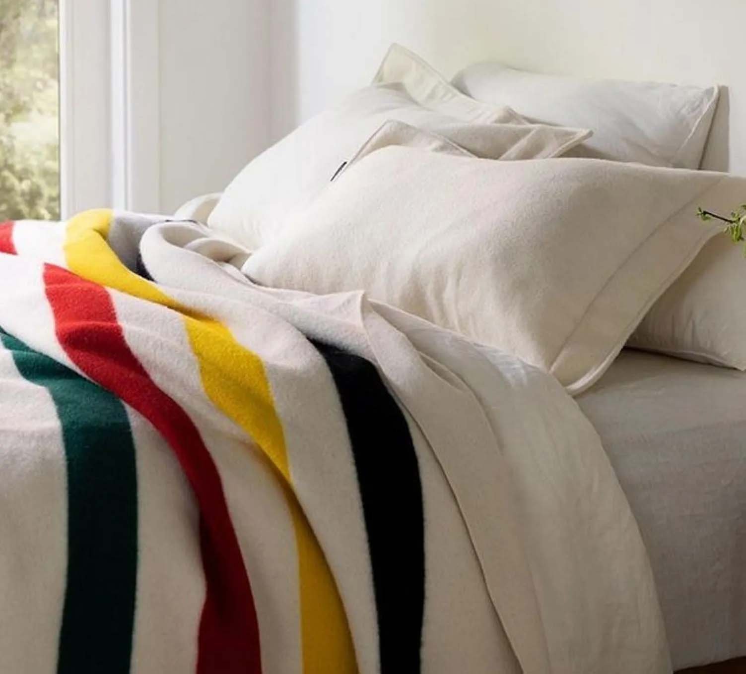 Pendleton Glacier National Park blanket on bed with white sheets and pillows