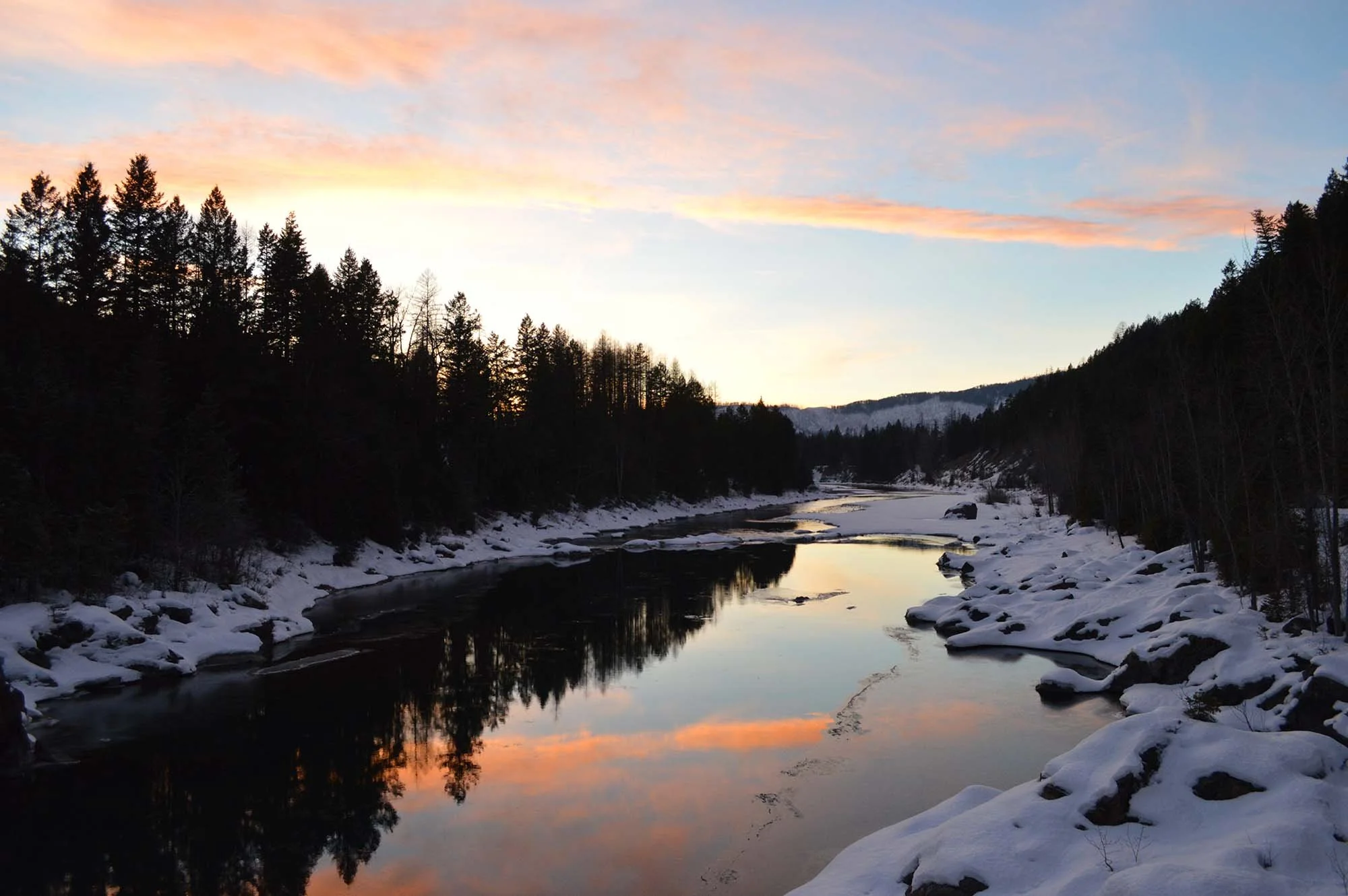 Swan River in Bigfork, Montana at sunset with snow on the ground