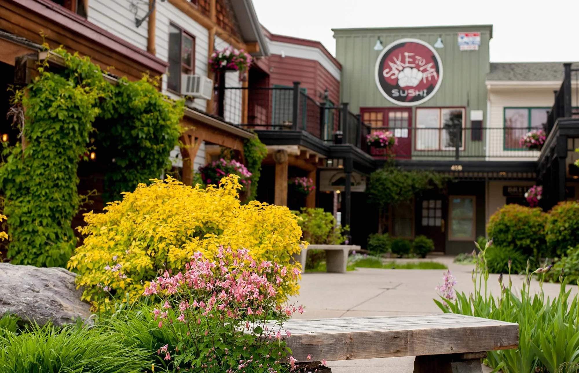 View of the plaza in Bigfork, Montana with Saketome Sushi restaurant in the background and spring flowers in the foreground