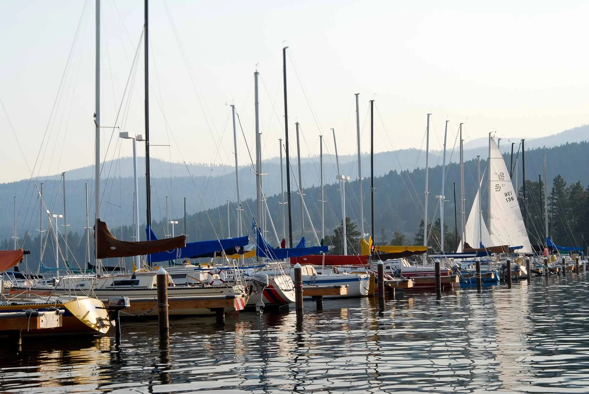 Sail boats moored at a Flathead Lake marina in Lakeside, Montana