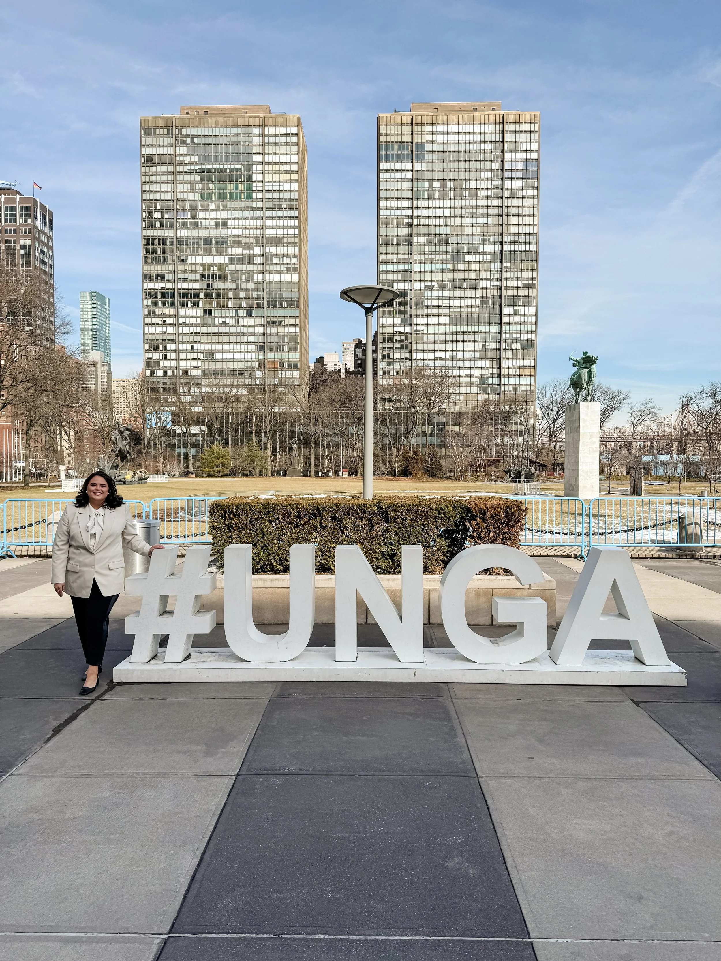 Woman standing next to lifesize #UNGA sign