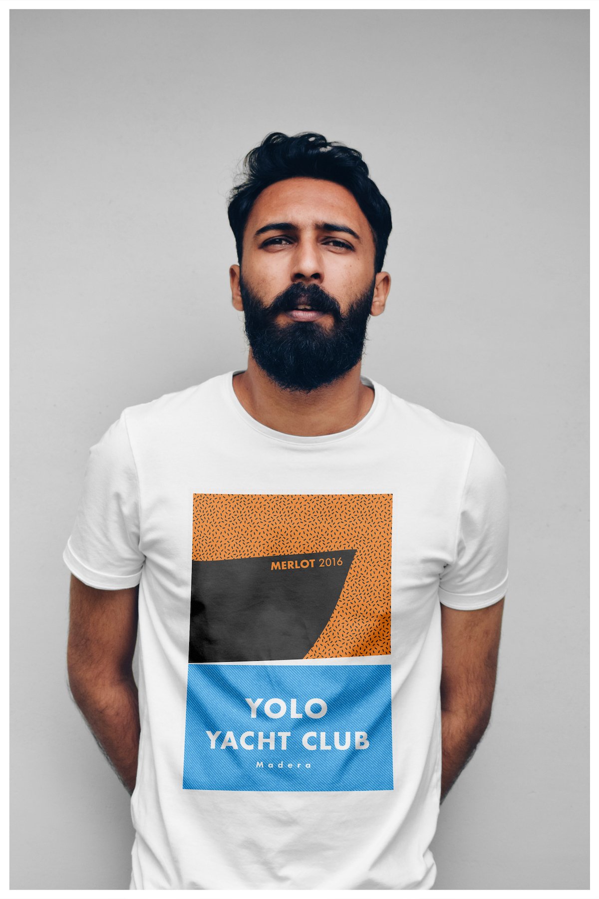 A t-shirt mockup using a design showcasing the fictitious company Yolo Yacht Club Wines with a minimalism approach. Poster design by Carmelo Rossette.