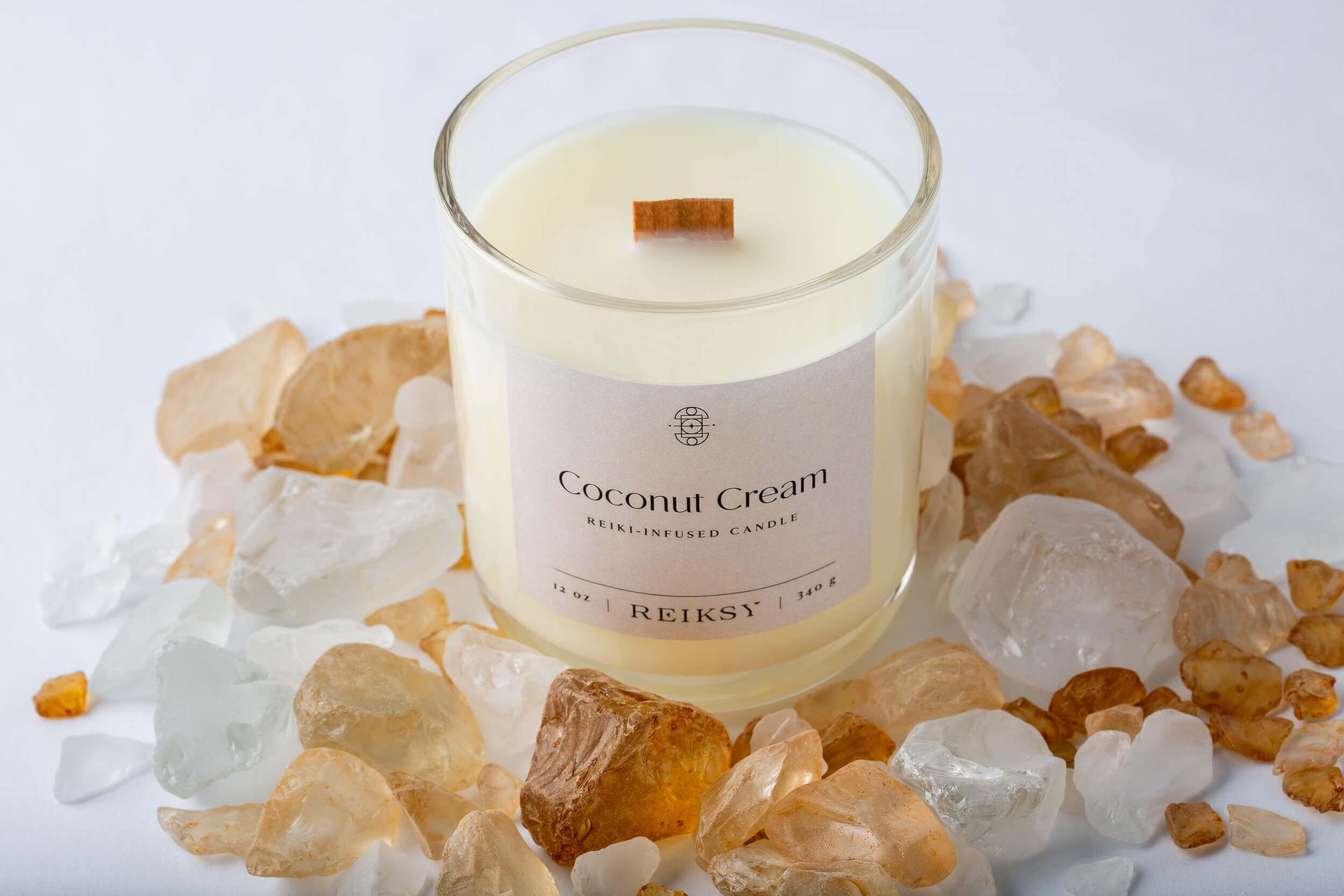 Coconut cream Reiksy reiki-infused candle surrounded by citrine stones.