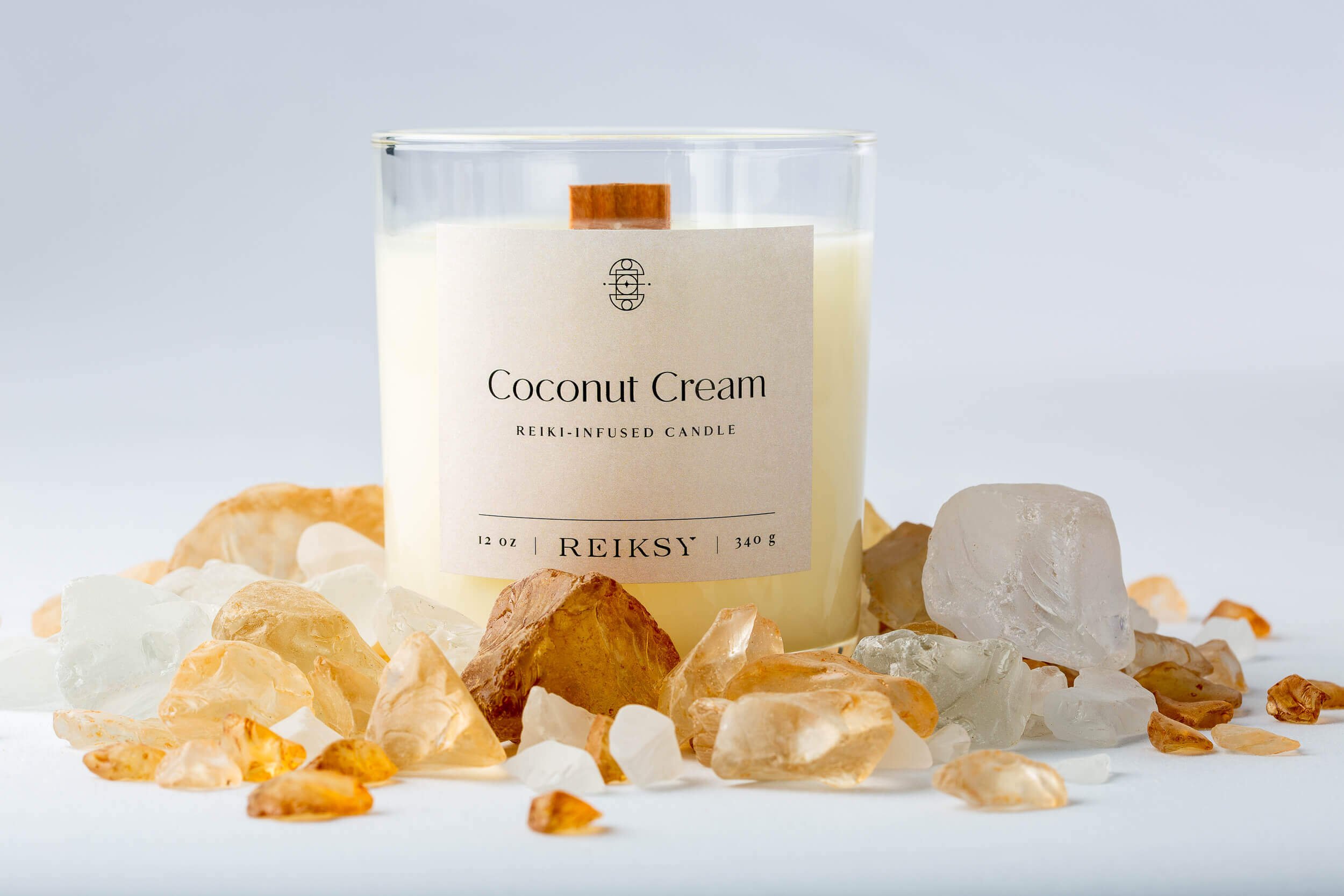 Coconut cream Reiksy reiki-infused candle surrounded by citrine stones.