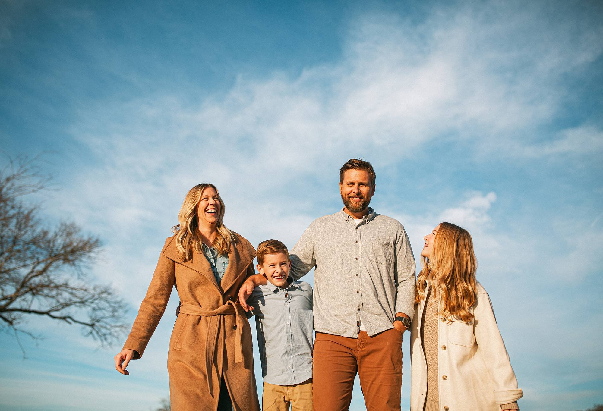 candid family photo in field with blue sky