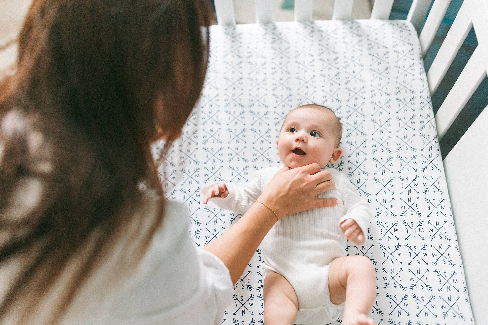 baby looking at mommy from crib