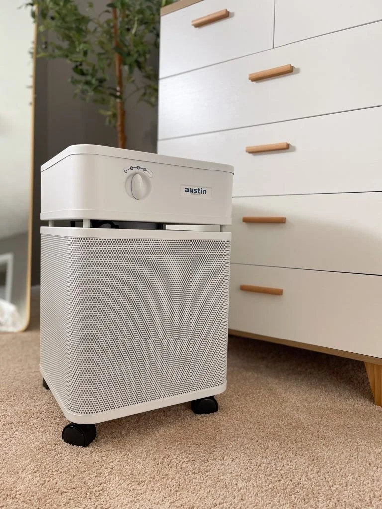 Austin Air HealthMate Plus air purifier placed in a bedroom for continuous air purification
