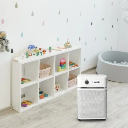 Austin Air HealthMate Plus Junior air purifier used in a children's playroom to help reduce dust, mold fragments, virus-containing airborne particles, and household pollutants.