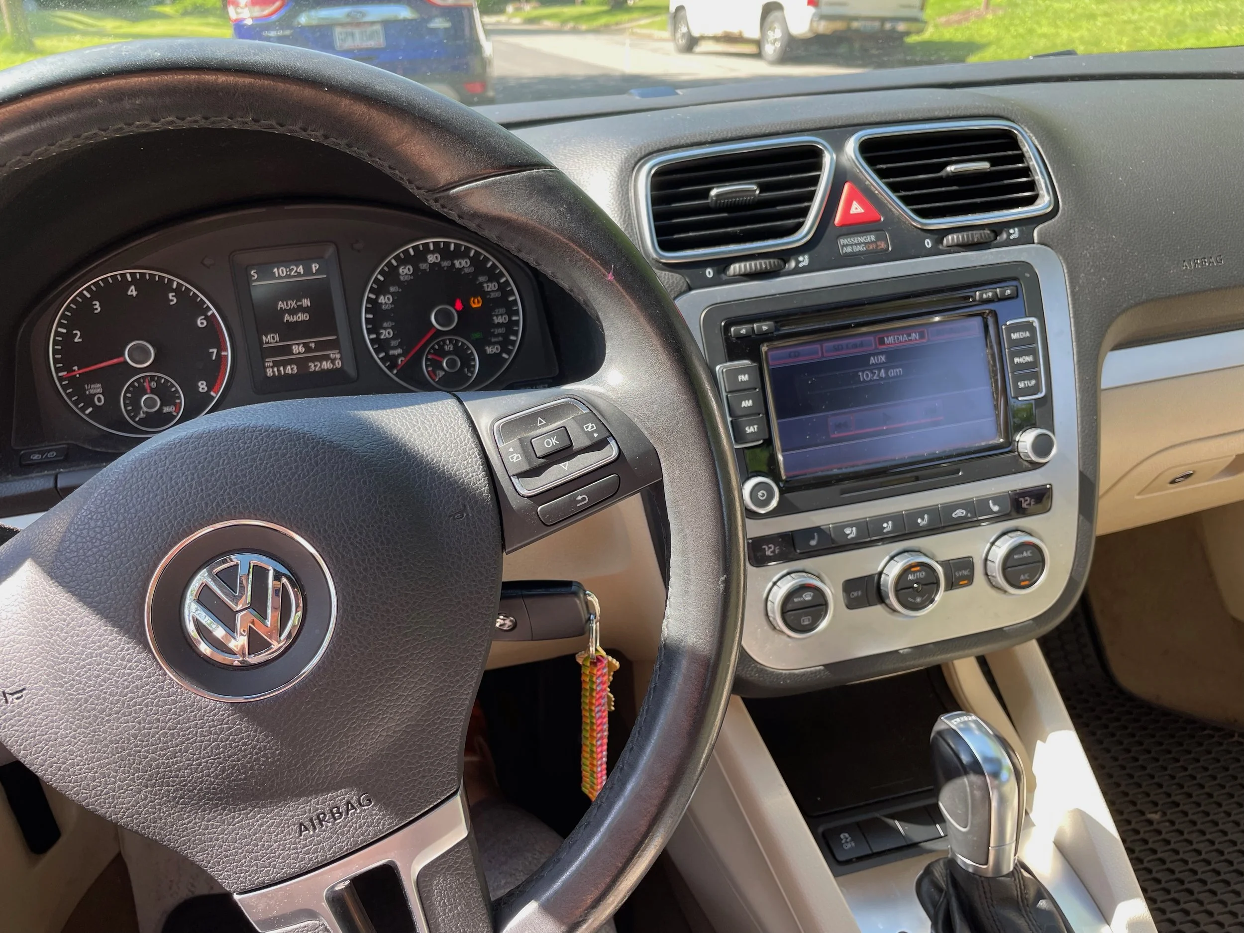 The interior of a Volkswagen car showing the dashboard, steering wheel, and center console. The dashboard includes speedometer, tachometer, and other gauges. The center console has a multimedia system displaying the time as 10:24 am, climate control