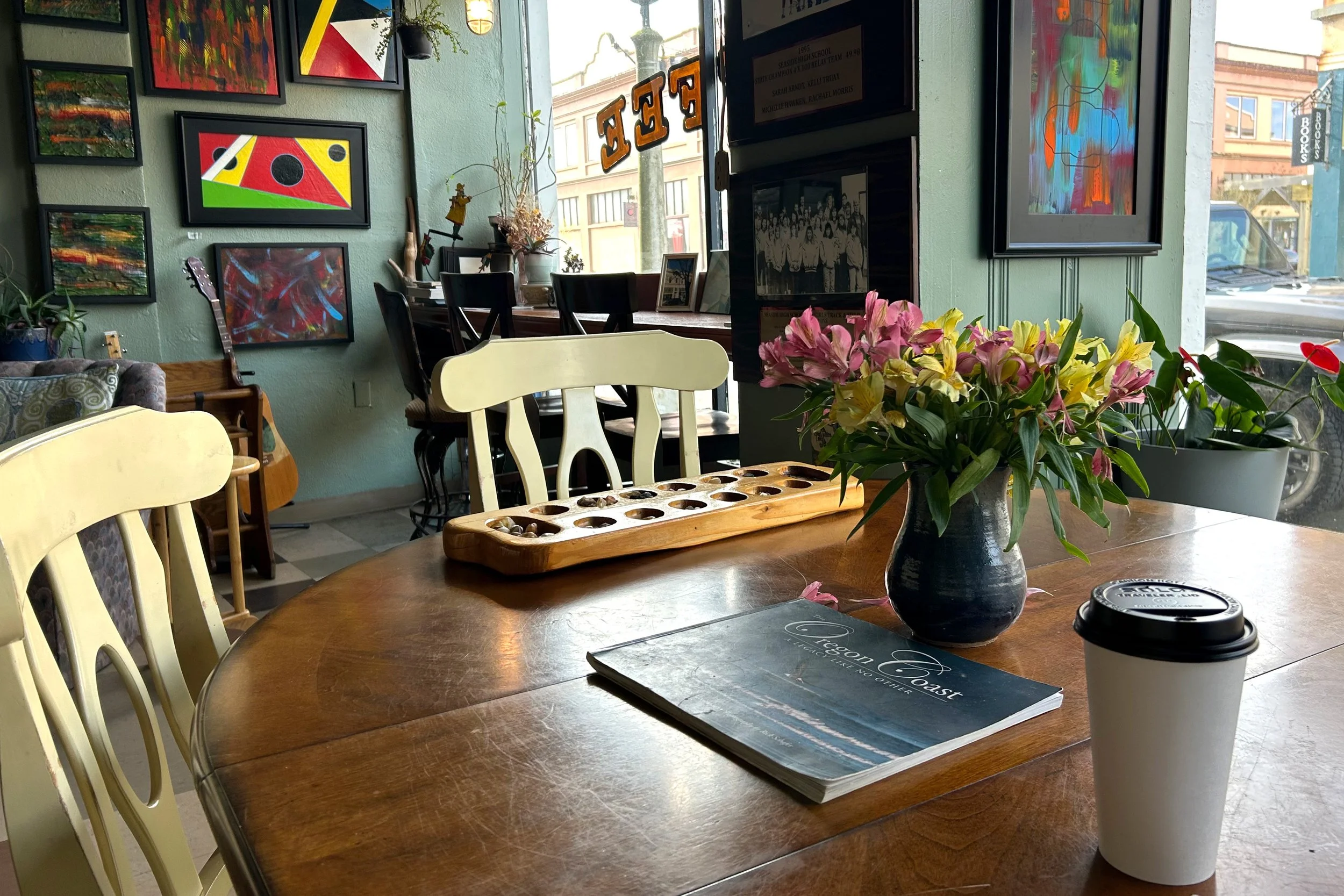 Cup of coffee in cafe with flowers in vase