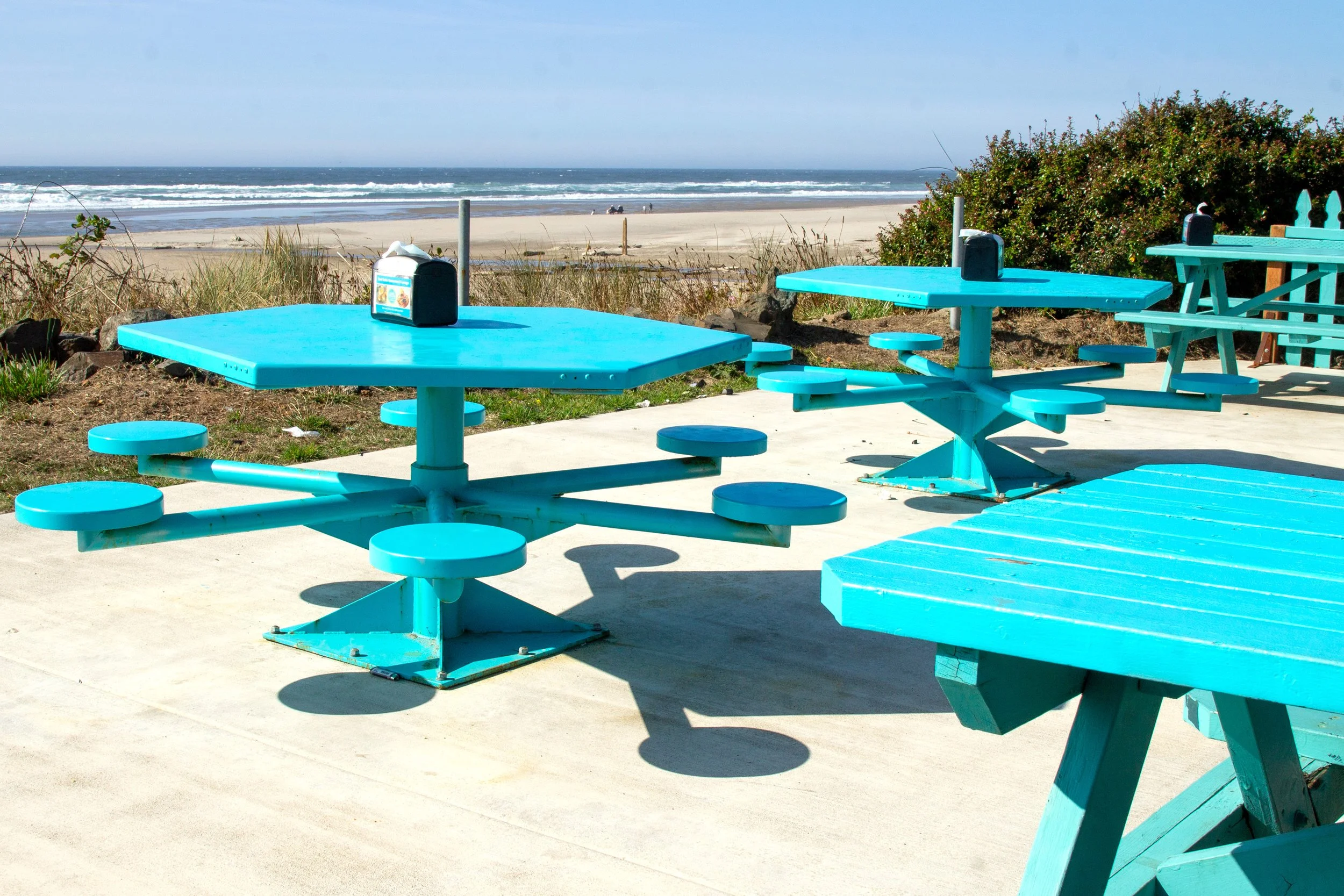 Turquoise picnic tables overlooking the ocean
