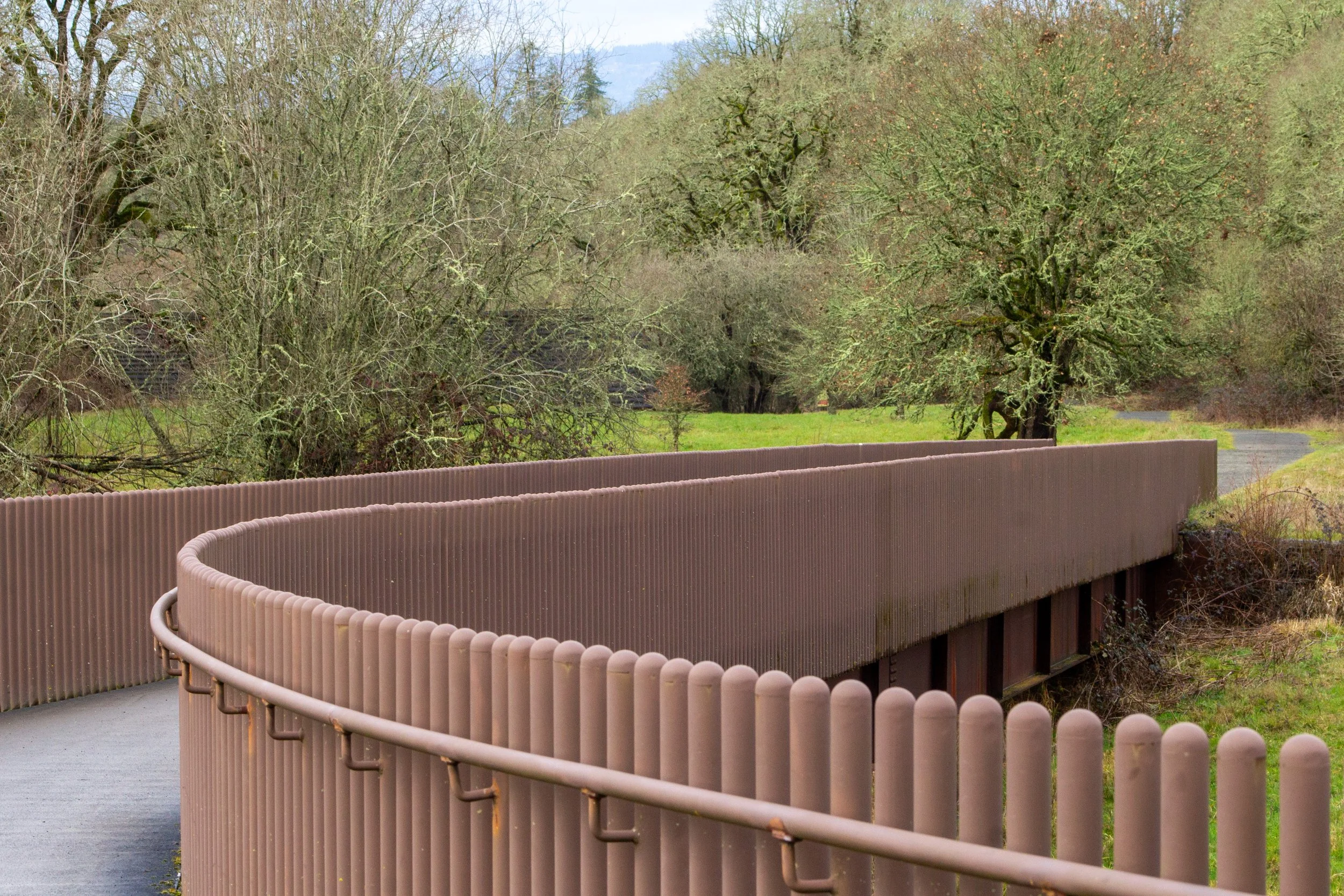 Wide paved trail with railings toward oak savanna