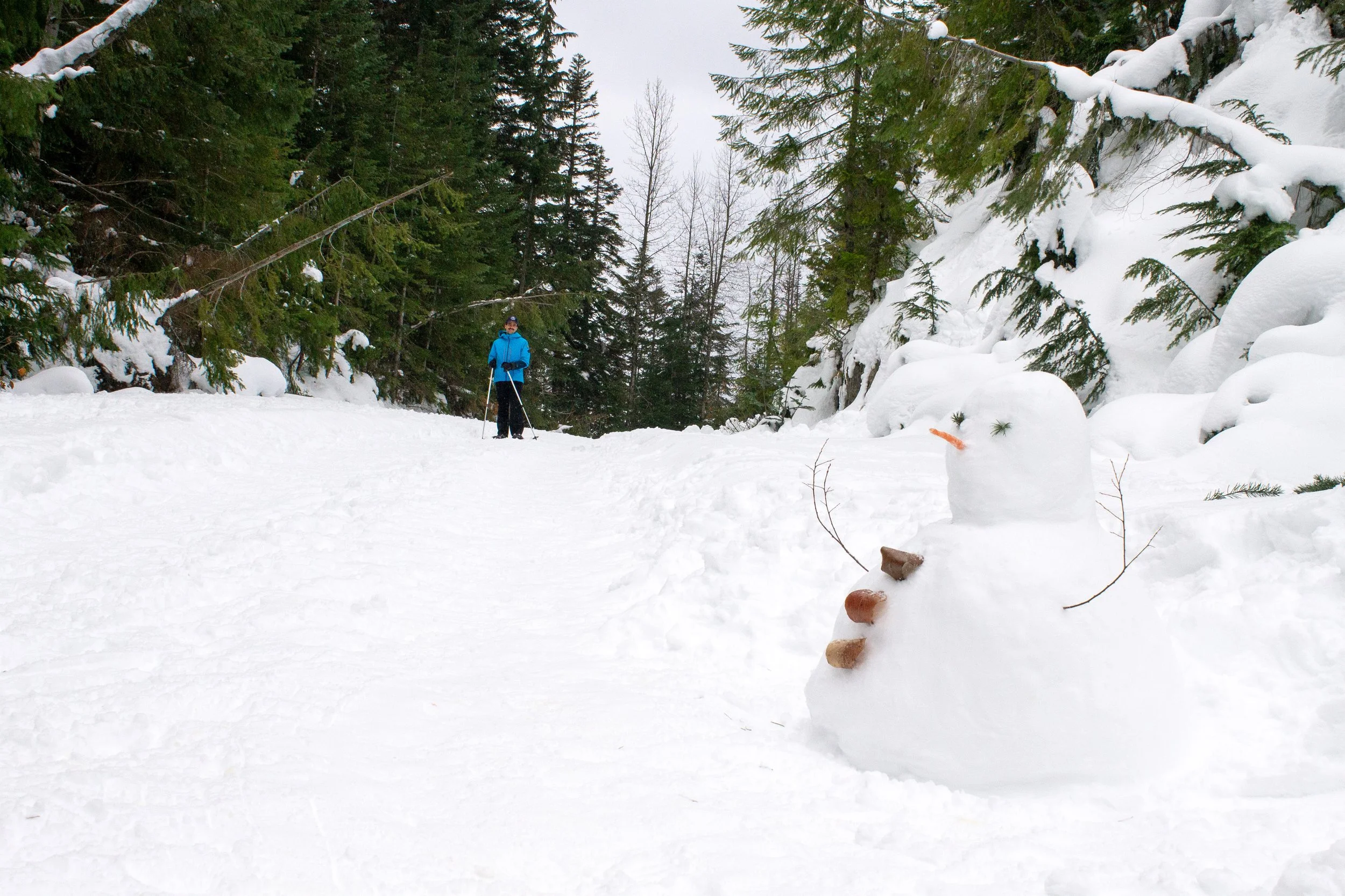 Snowman next to snowshoeing trail