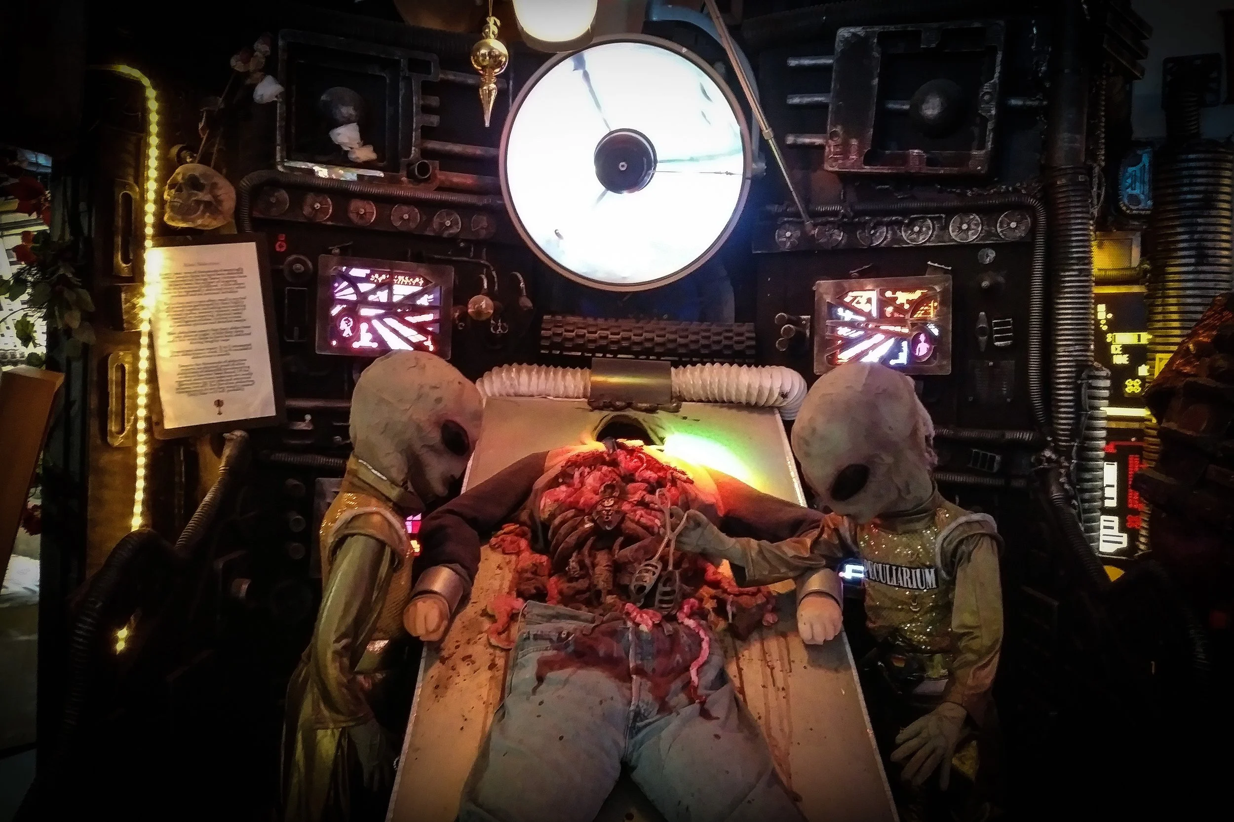 Aliens stand next to eviscerated corpse